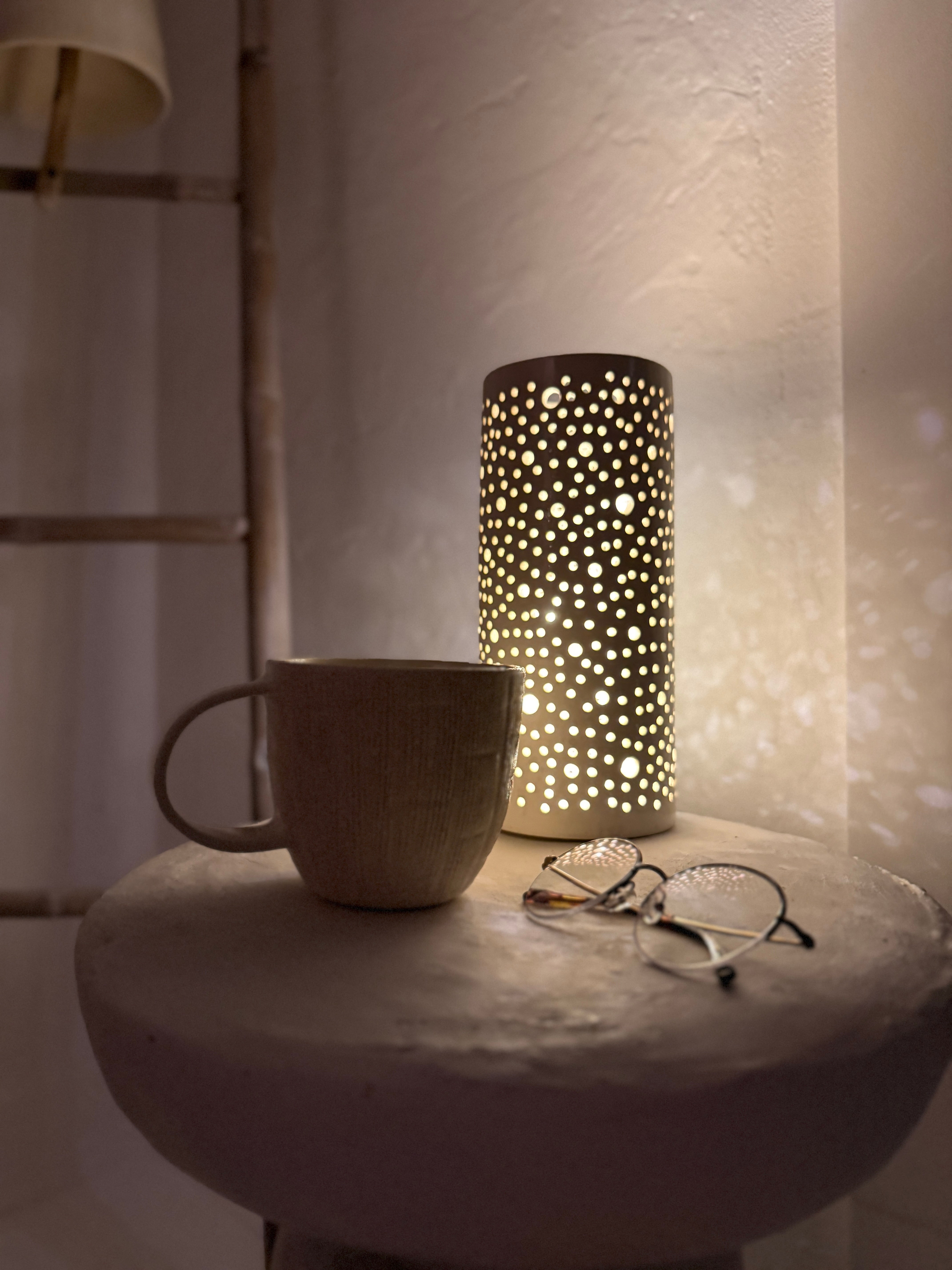 Handmade ceramic mug with deep carved vertical lines and a textured neutral glaze.