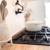 Textured ceramic pedestal utensil holder in a neutral finish