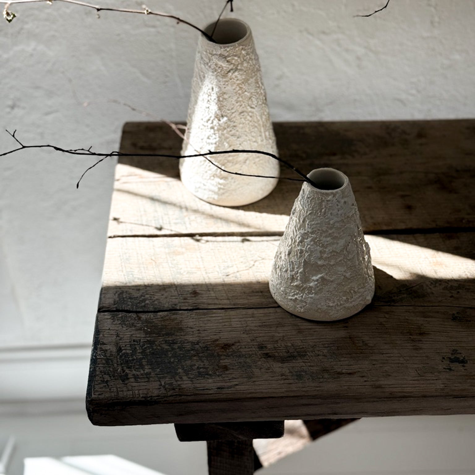 Handmade conical ceramic vase with a sculptural silhouette and a textured neutral finish.