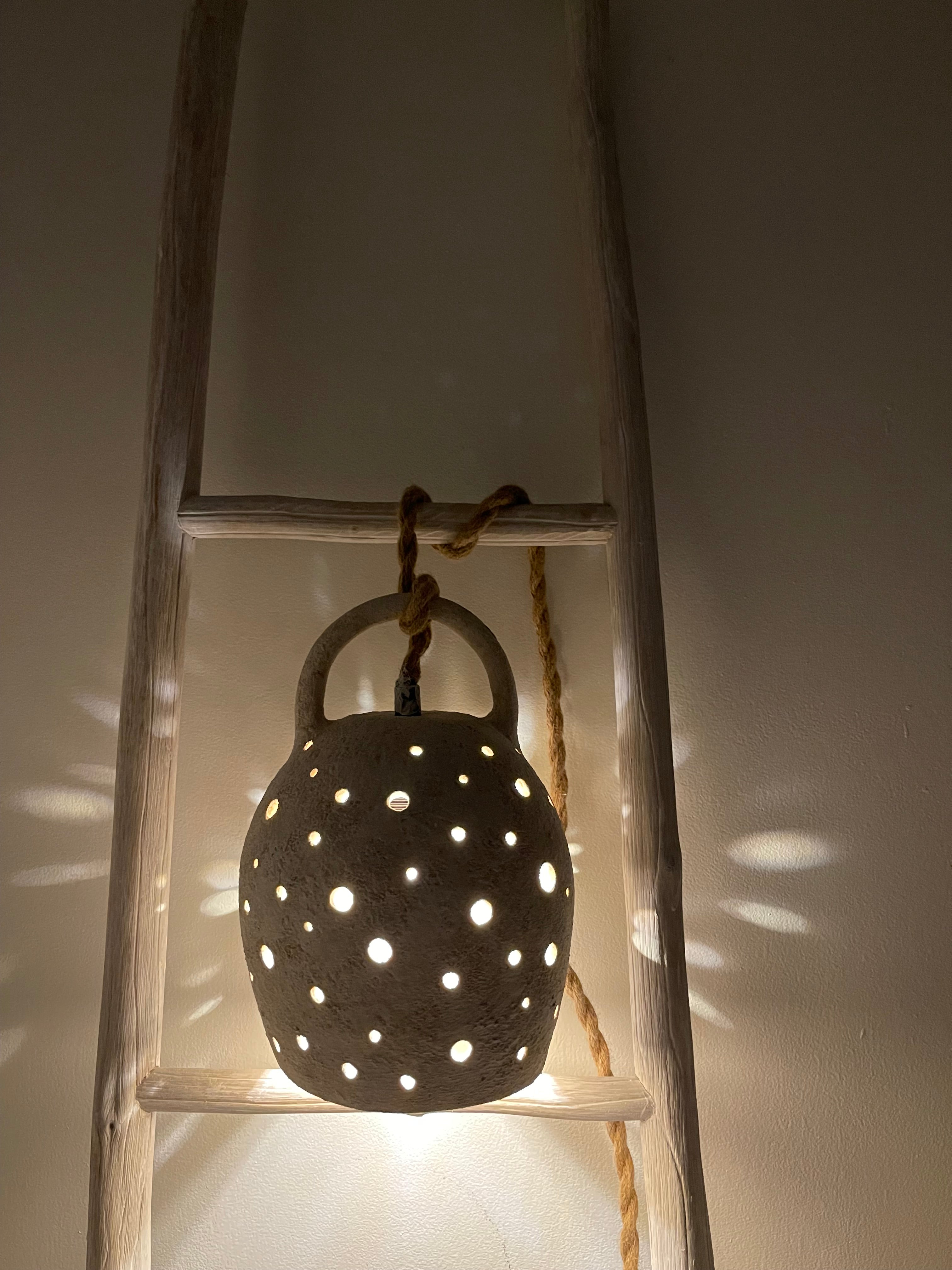 Handmade stoneware pendant lamp with hand-carved star cutouts