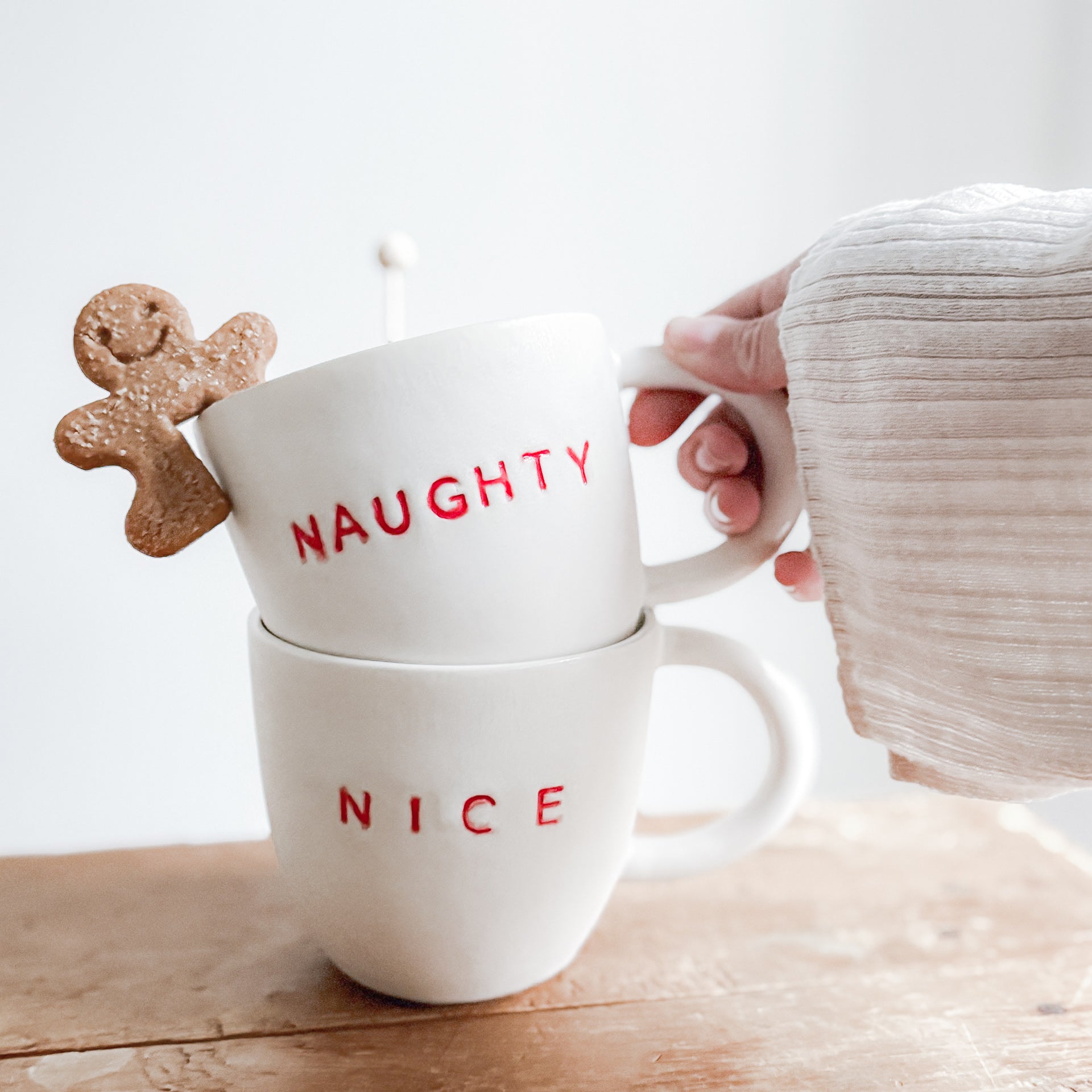 Handmade ceramic holiday mug lettered Naughty and Nice in a neutral glaze