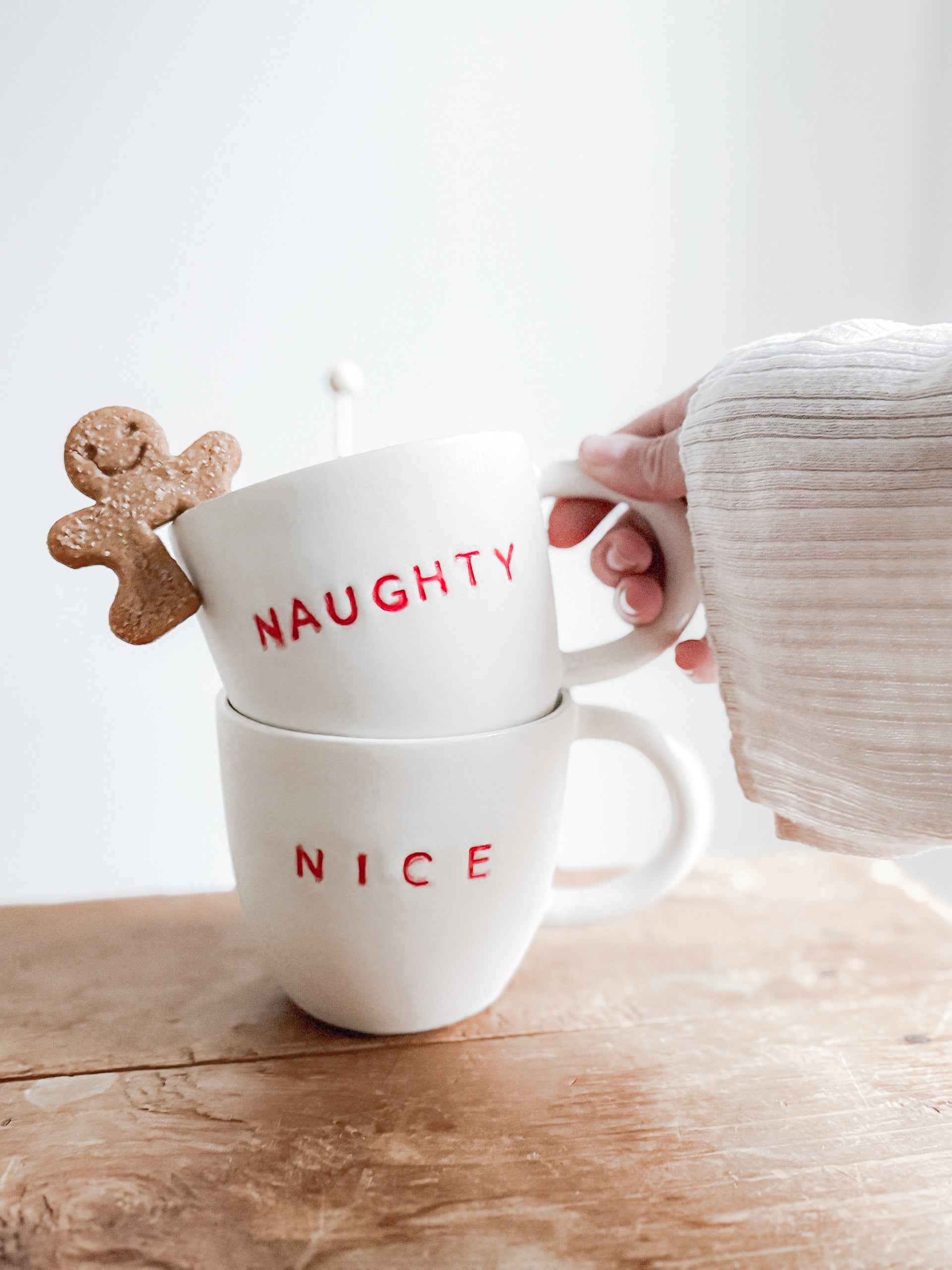 Handmade ceramic holiday mug lettered Naughty and Nice in a neutral glaze