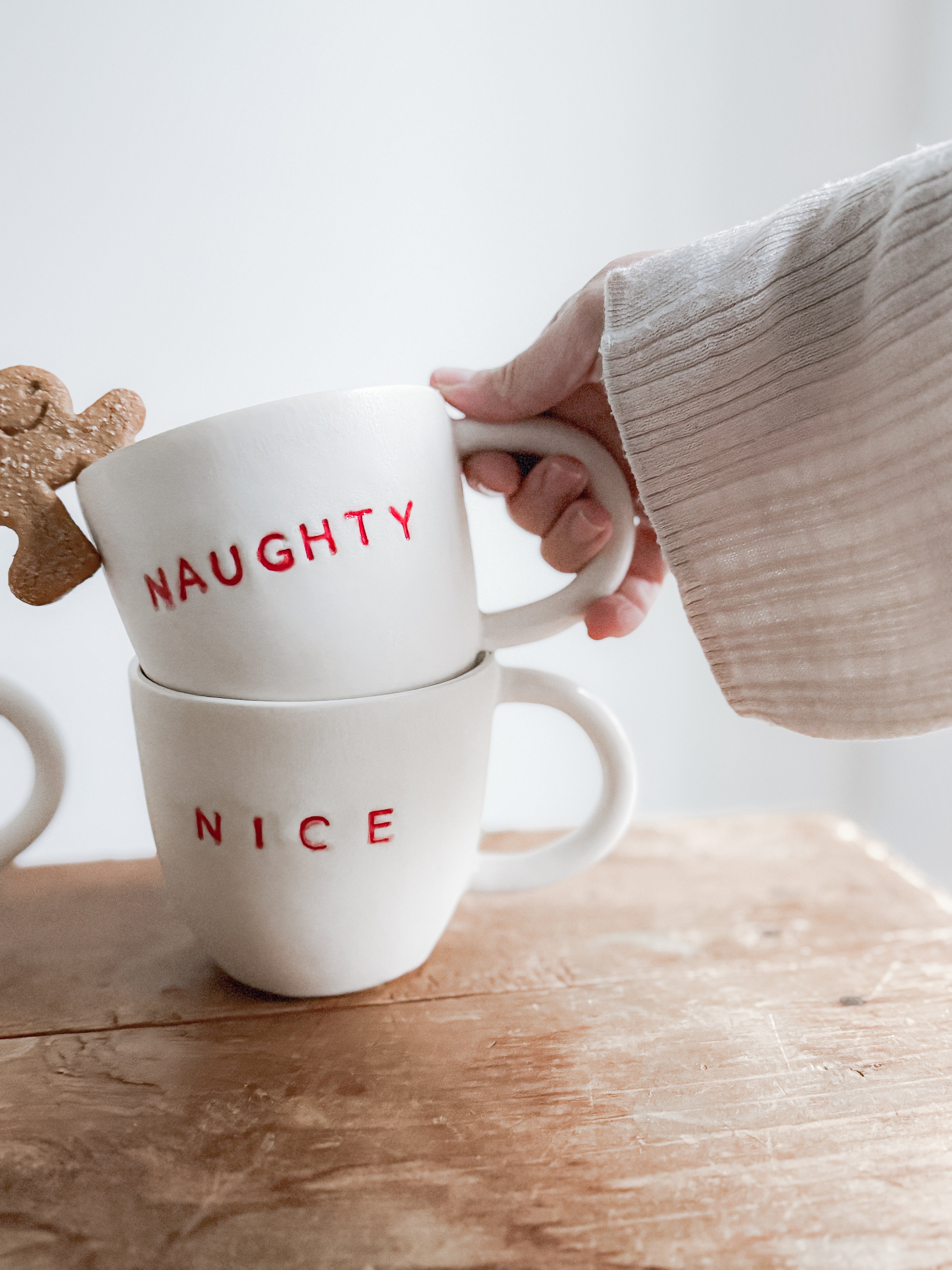 Handmade ceramic holiday mug lettered Naughty and Nice in a neutral glaze