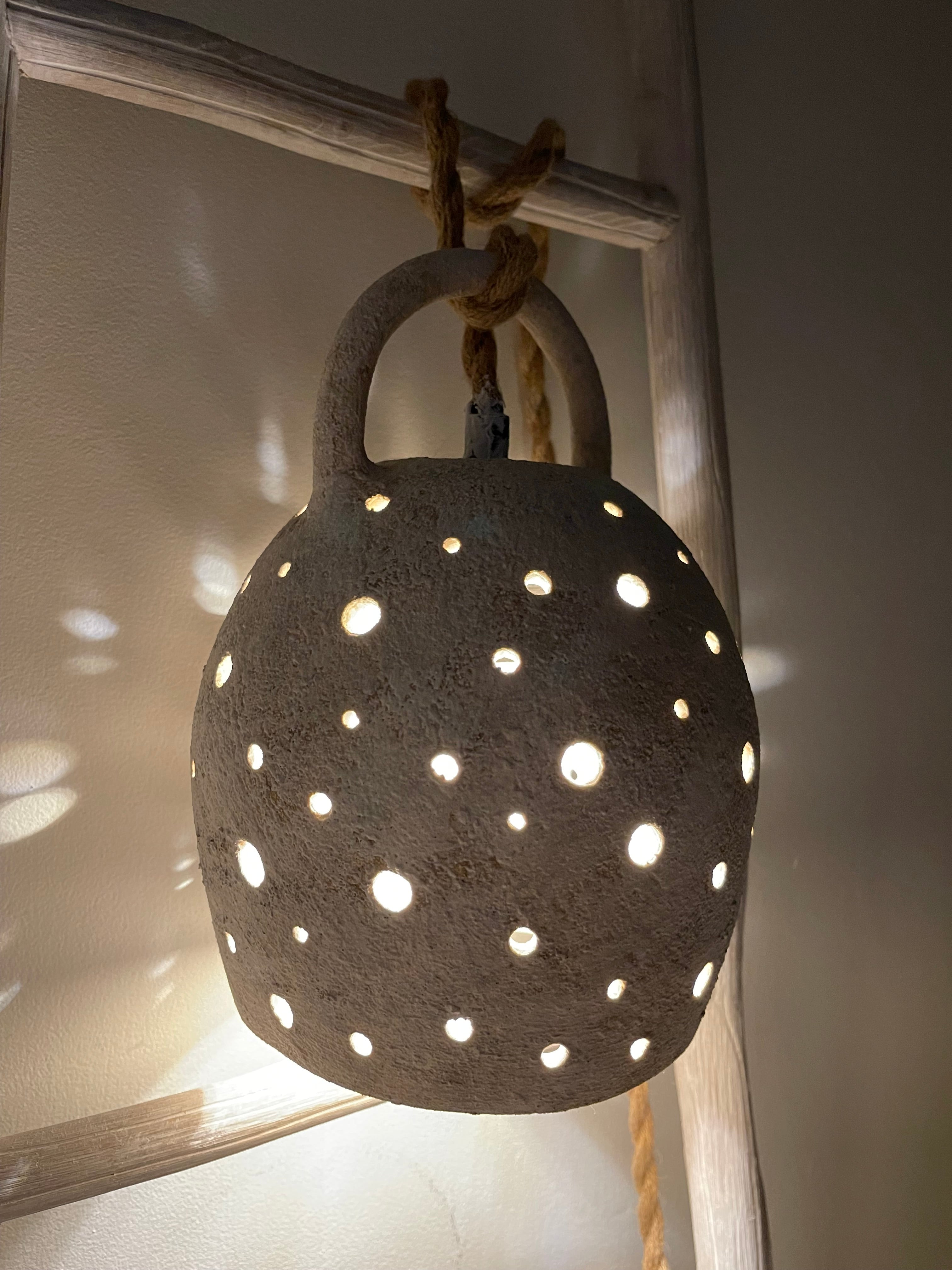 Handmade stoneware pendant lamp with hand-carved star cutouts