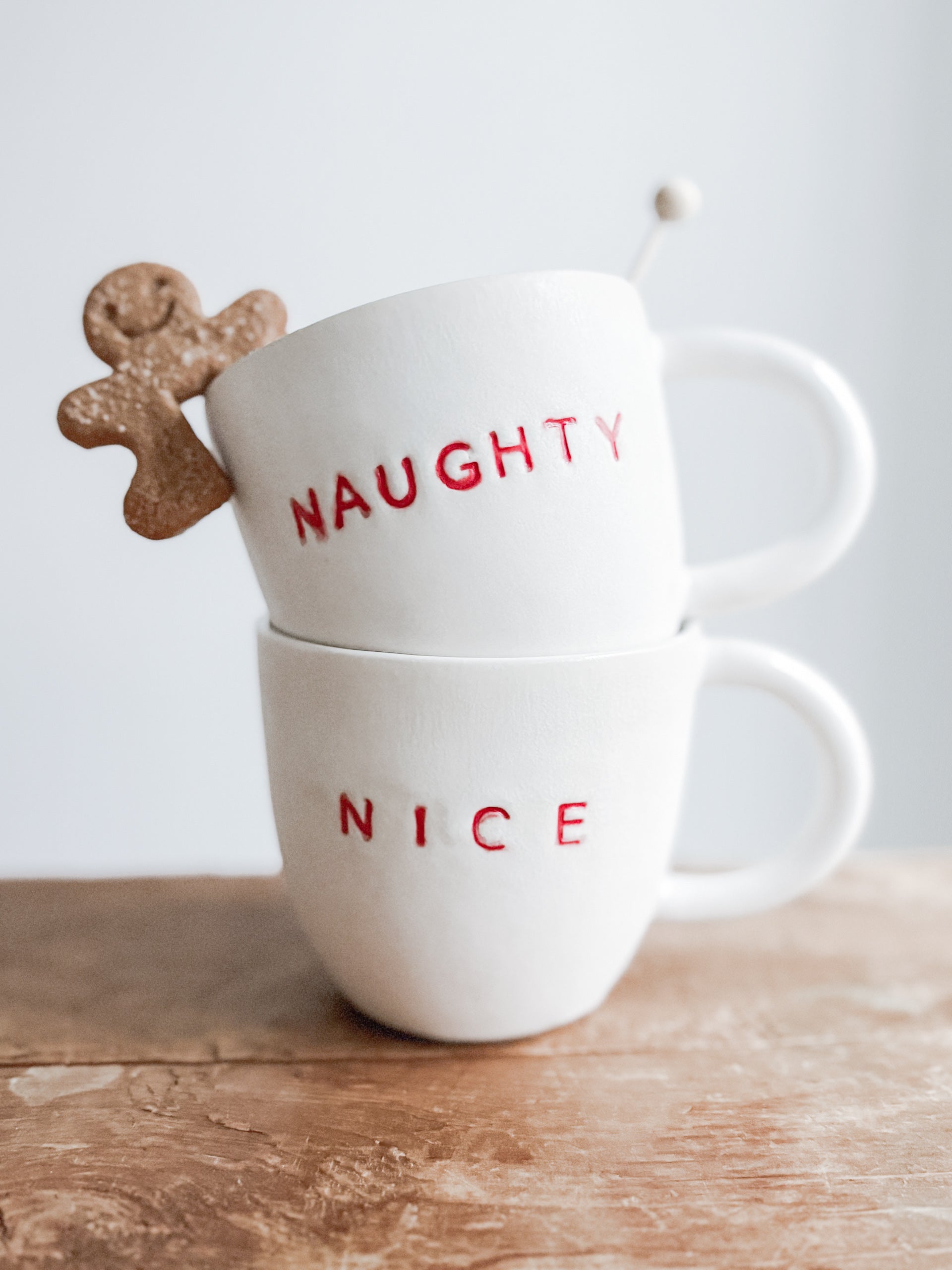 Handmade ceramic holiday mug lettered Naughty and Nice in a neutral glaze