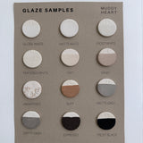 Ceramic glaze sample tiles showing Muddy Heart's range of neutral finishes