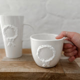 Handmade ceramic mug with a hand-painted holiday wreath and bow