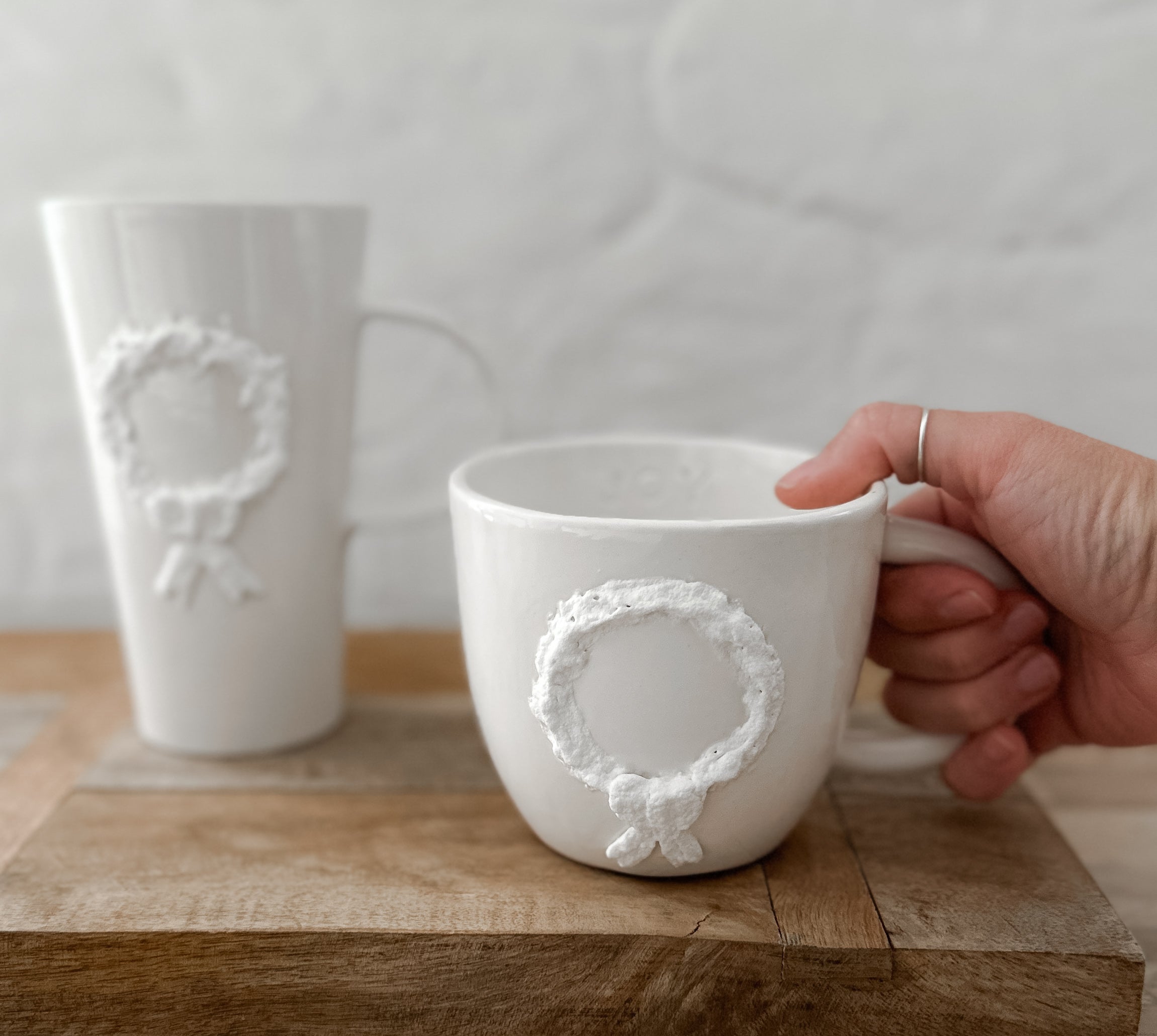 Handmade ceramic mug with a hand-painted holiday wreath and bow