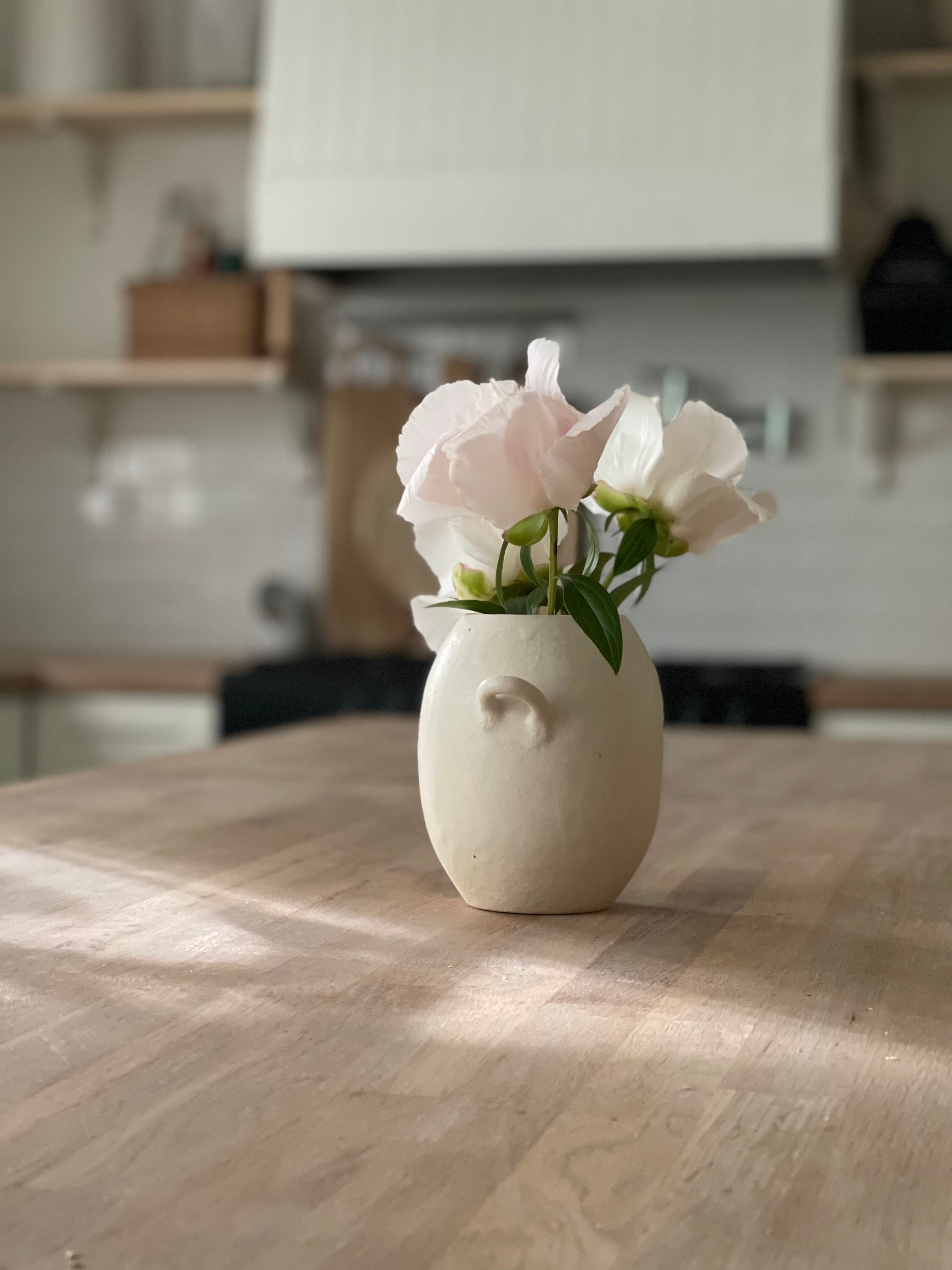 Handmade ceramic bud vase with a bellied shape and small handle