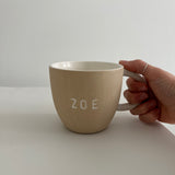 Personalized deep ceramic mug hand-lettered with a name in an earthy neutral tone