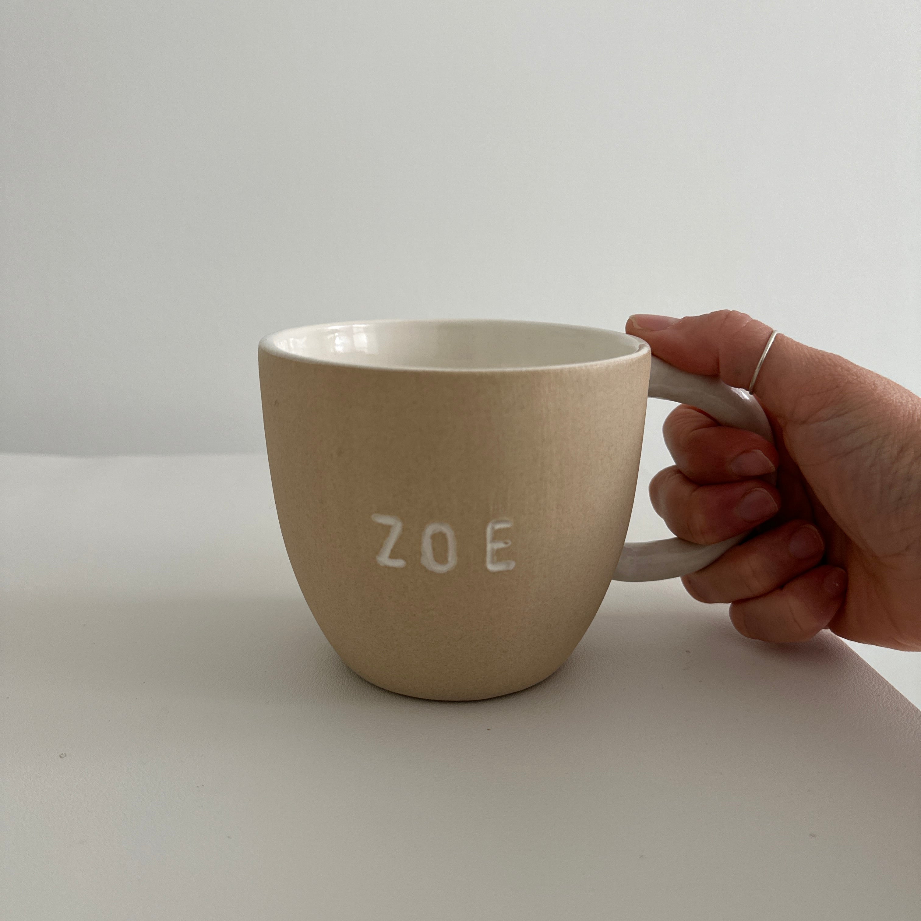 Personalized deep ceramic mug hand-lettered with a name in an earthy neutral tone