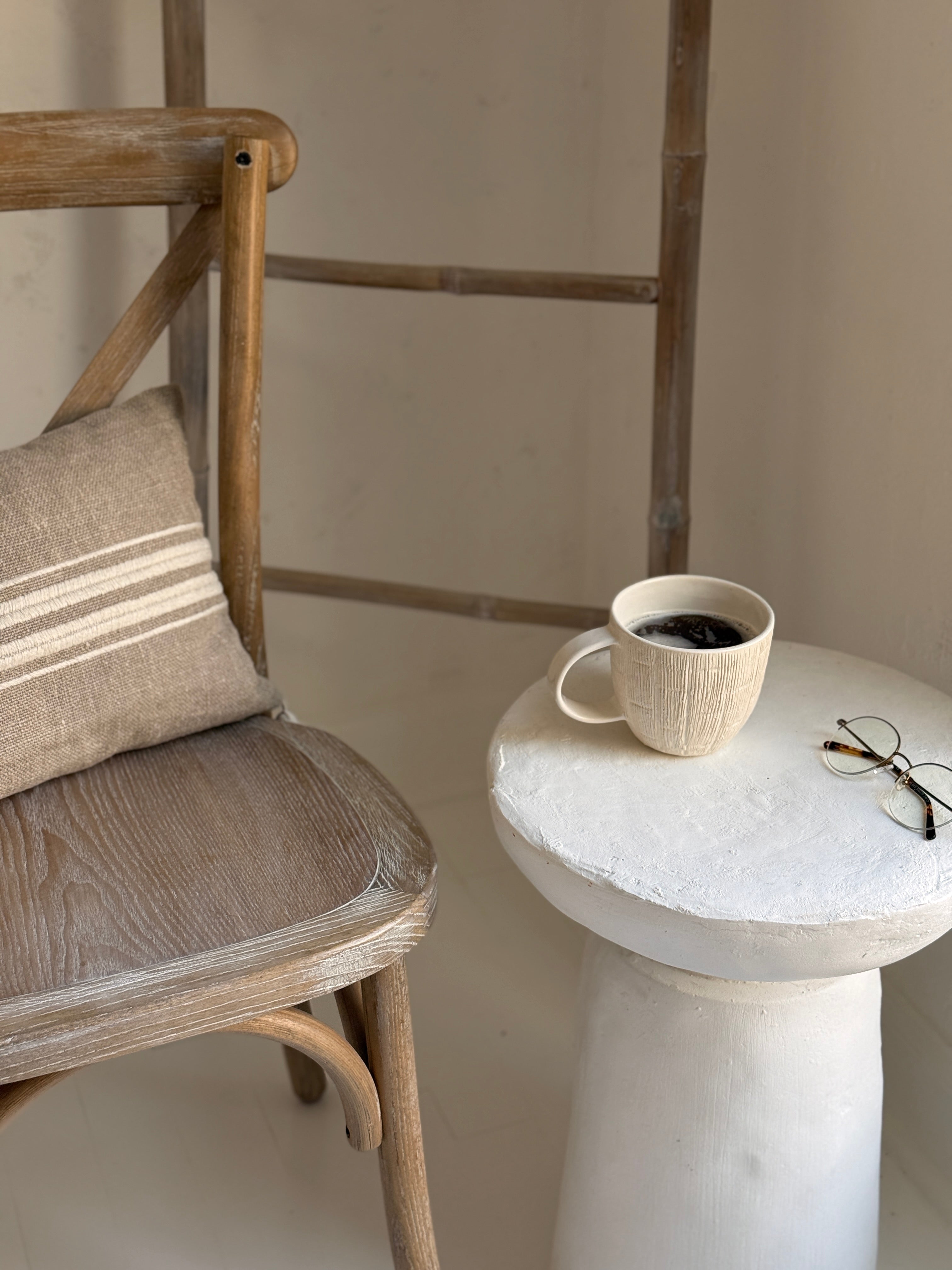 Handmade ceramic mug with deep carved vertical lines and a textured neutral glaze.
