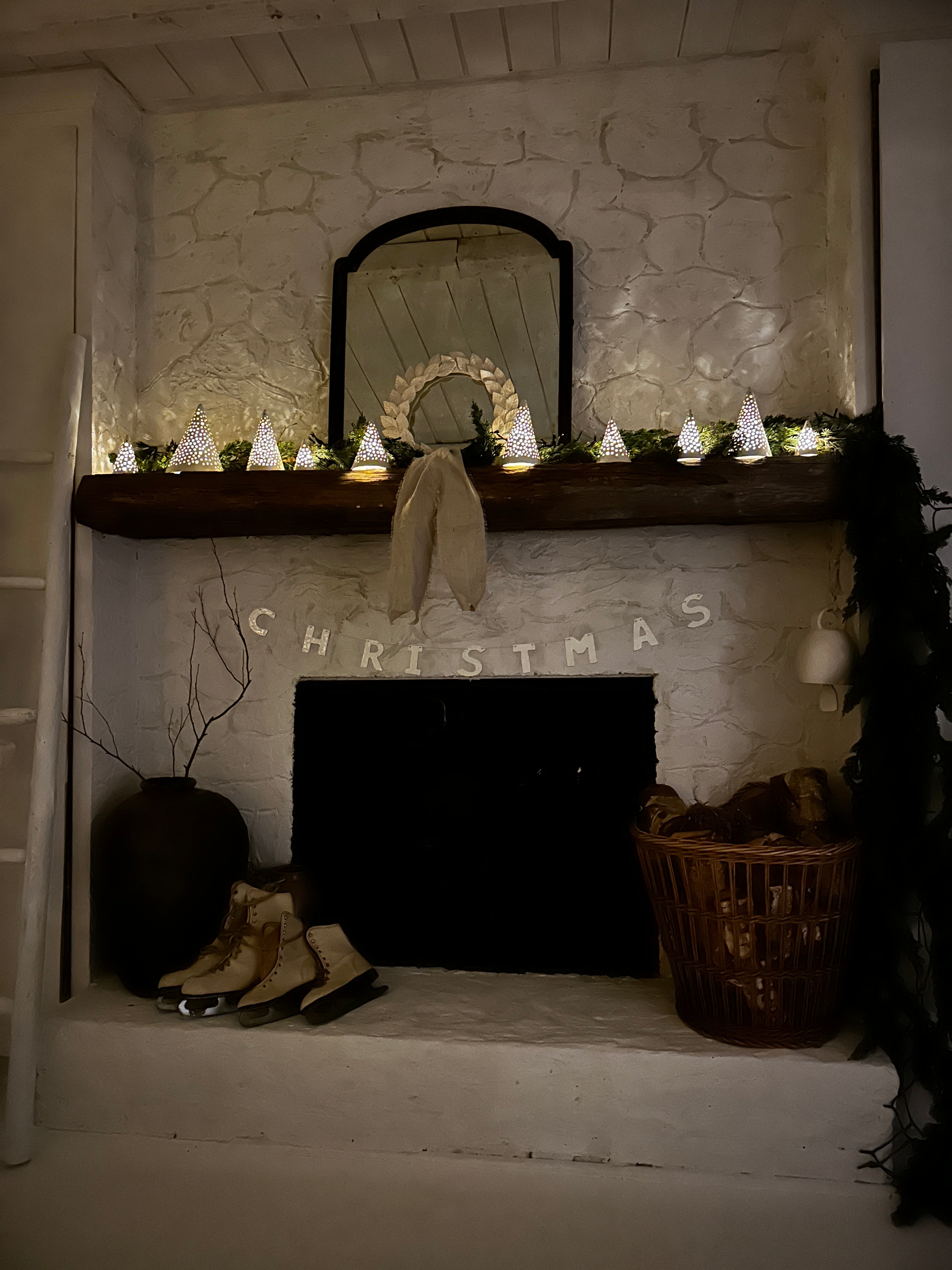 Handmade white stoneware tree luminaries with star cutouts glowing with LED tealight candles