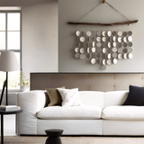 Modern coastal wall decor with natural driftwood and ceramic discs, wabi sabi  style
