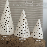 Three handmade ceramic tree luminaries in small, medium, and large sizes with cutout star-like holes.