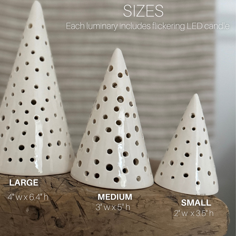 Three handmade ceramic tree luminaries in small, medium, and large sizes with cutout star-like holes.