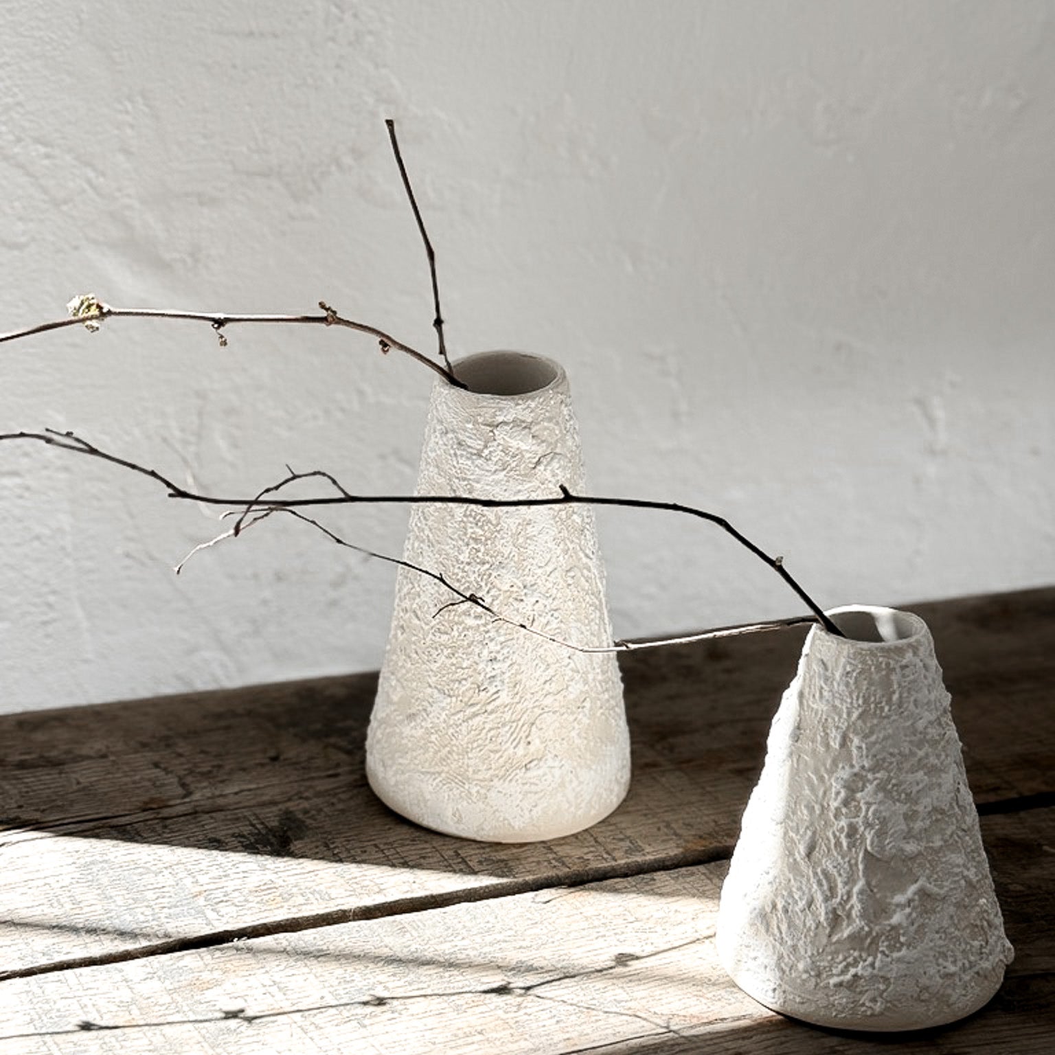 Handmade conical ceramic vase with a sculptural silhouette and a textured neutral finish.