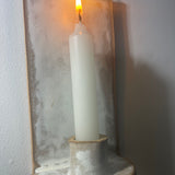 Handmade stoneware wall sconce holding a taper candle, hung from wire