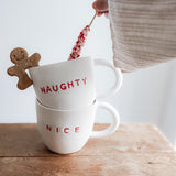 Handmade ceramic holiday mug lettered Naughty and Nice in a neutral glaze