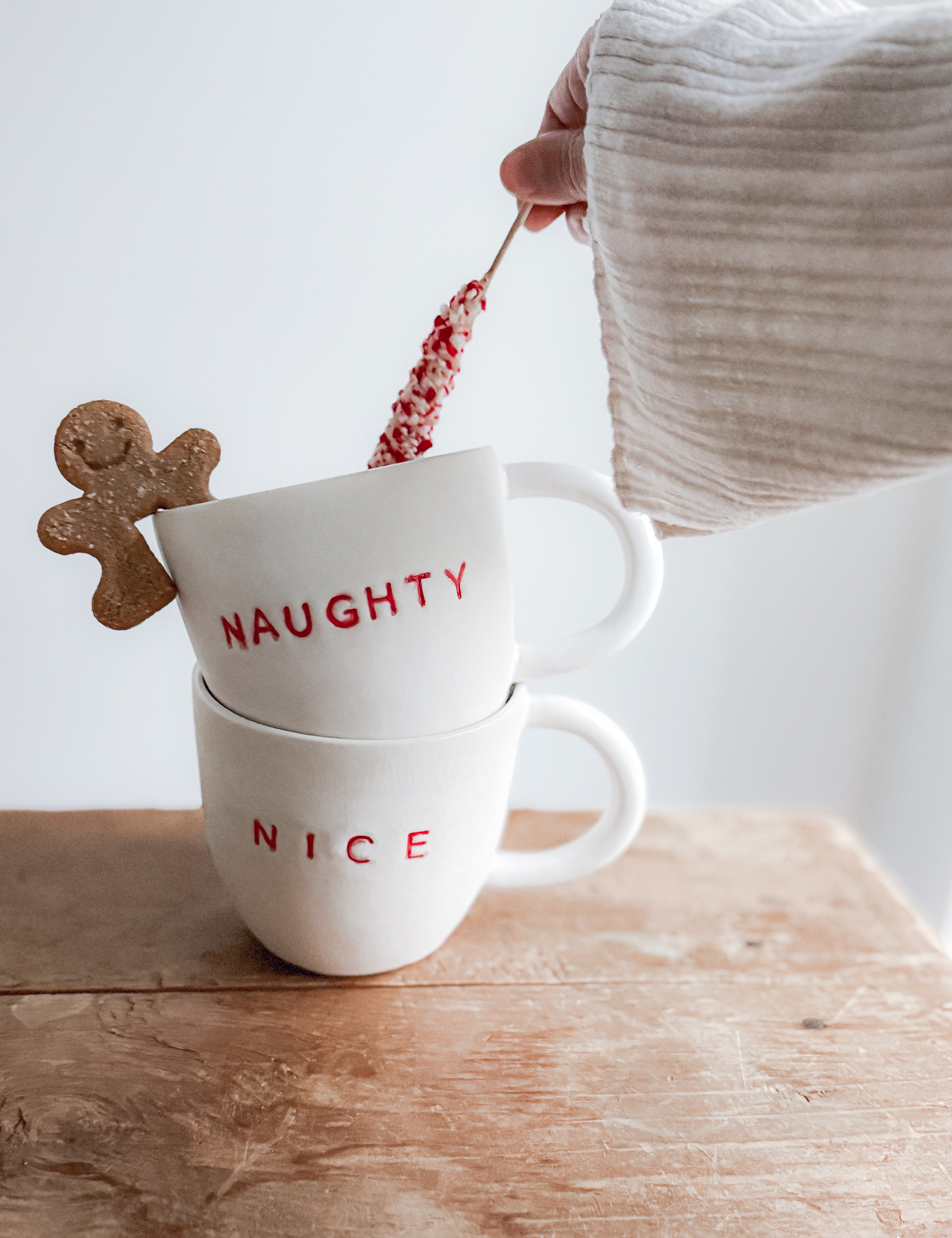 Handmade ceramic holiday mug lettered Naughty and Nice in a neutral glaze