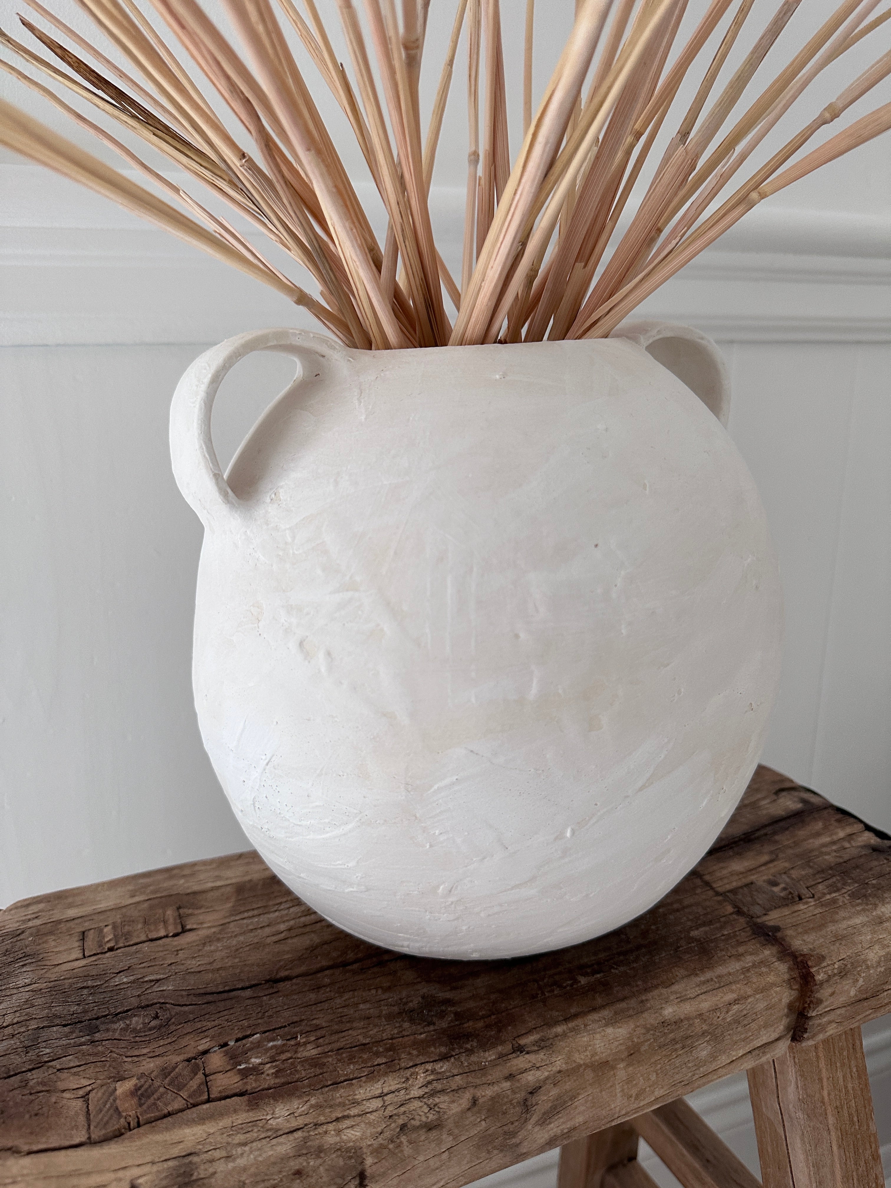 Handmade globe-shaped ceramic vessel with handles in a neutral glaze