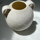 Handmade globe-shaped ceramic vessel with handles in a neutral glaze