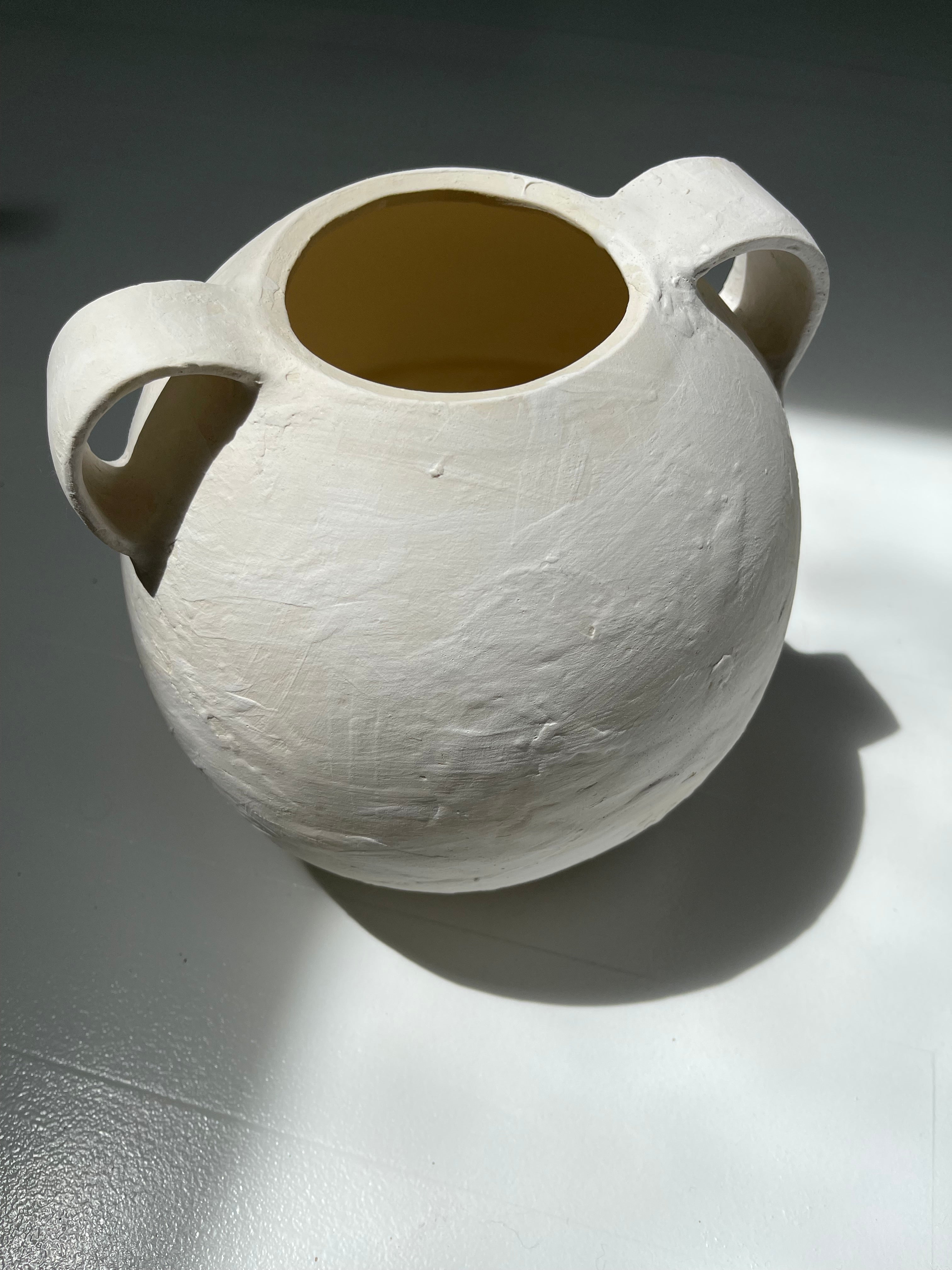 Handmade globe-shaped ceramic vessel with handles in a neutral glaze