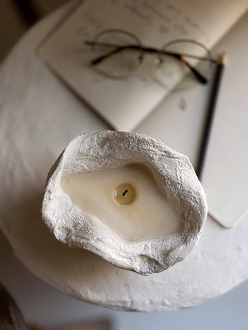 Handmade ceramic soy candle in a ruffled-edge vessel with a textured neutral finish, reusable after burning.
