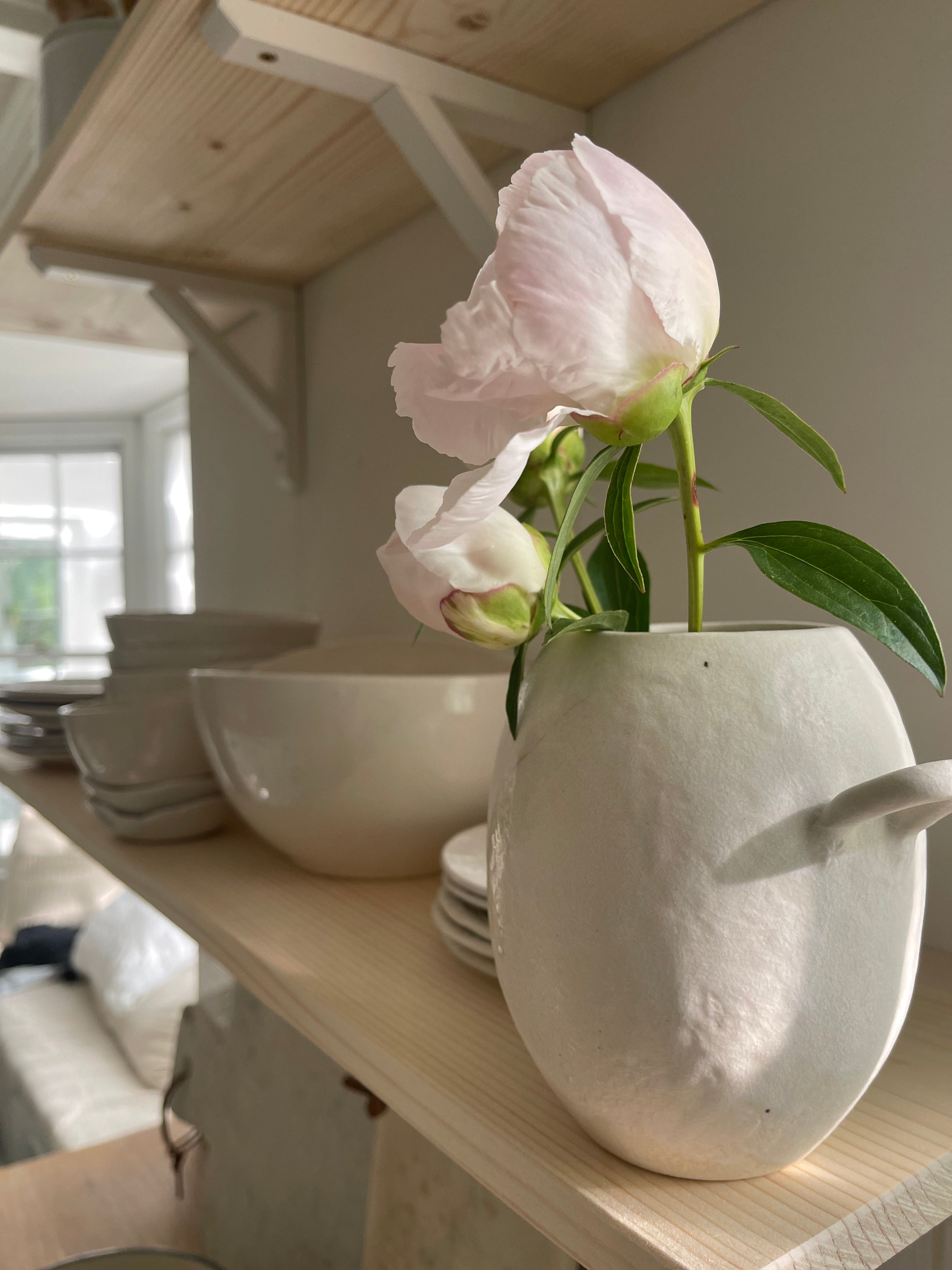 Handmade ceramic bud vase with a bellied shape and small handle