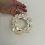 Personalized porcelain laurel wreath ornament with a gloss-white glaze and custom name on linen twine