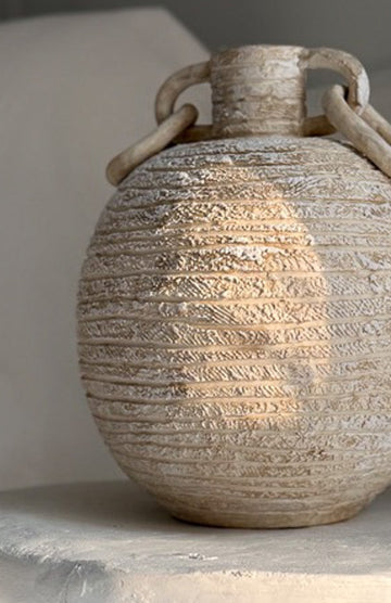 Handmade globe-shaped ceramic vessel with sculptural ring handles, glazed inside and out in a neutral finish.