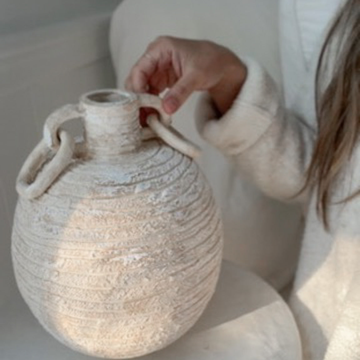 Handmade globe-shaped ceramic vessel with sculptural ring handles, glazed inside and out in a neutral finish.