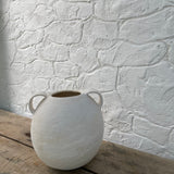 Handmade globe-shaped ceramic vessel with handles in a neutral glaze
