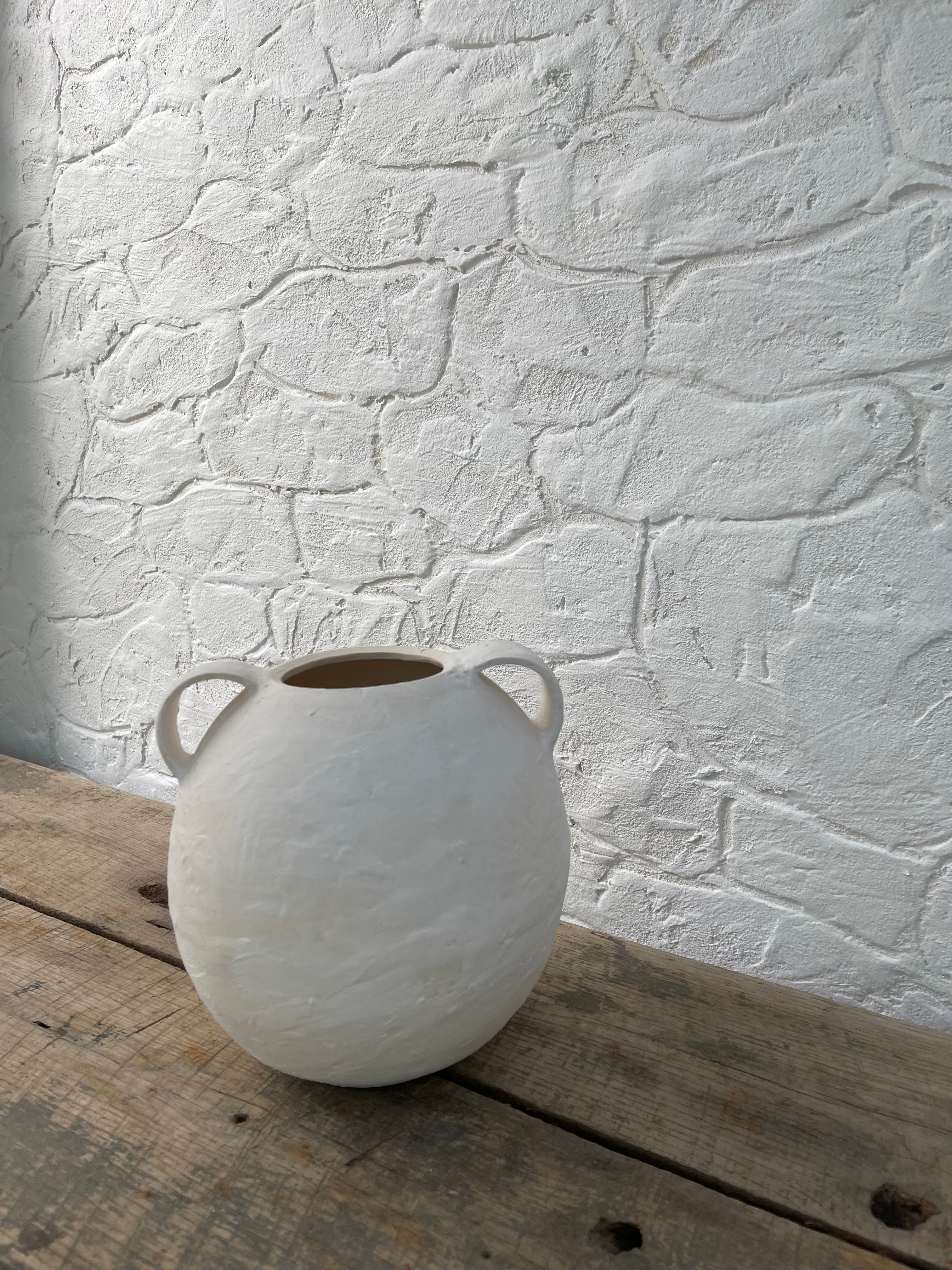 Handmade globe-shaped ceramic vessel with handles in a neutral glaze