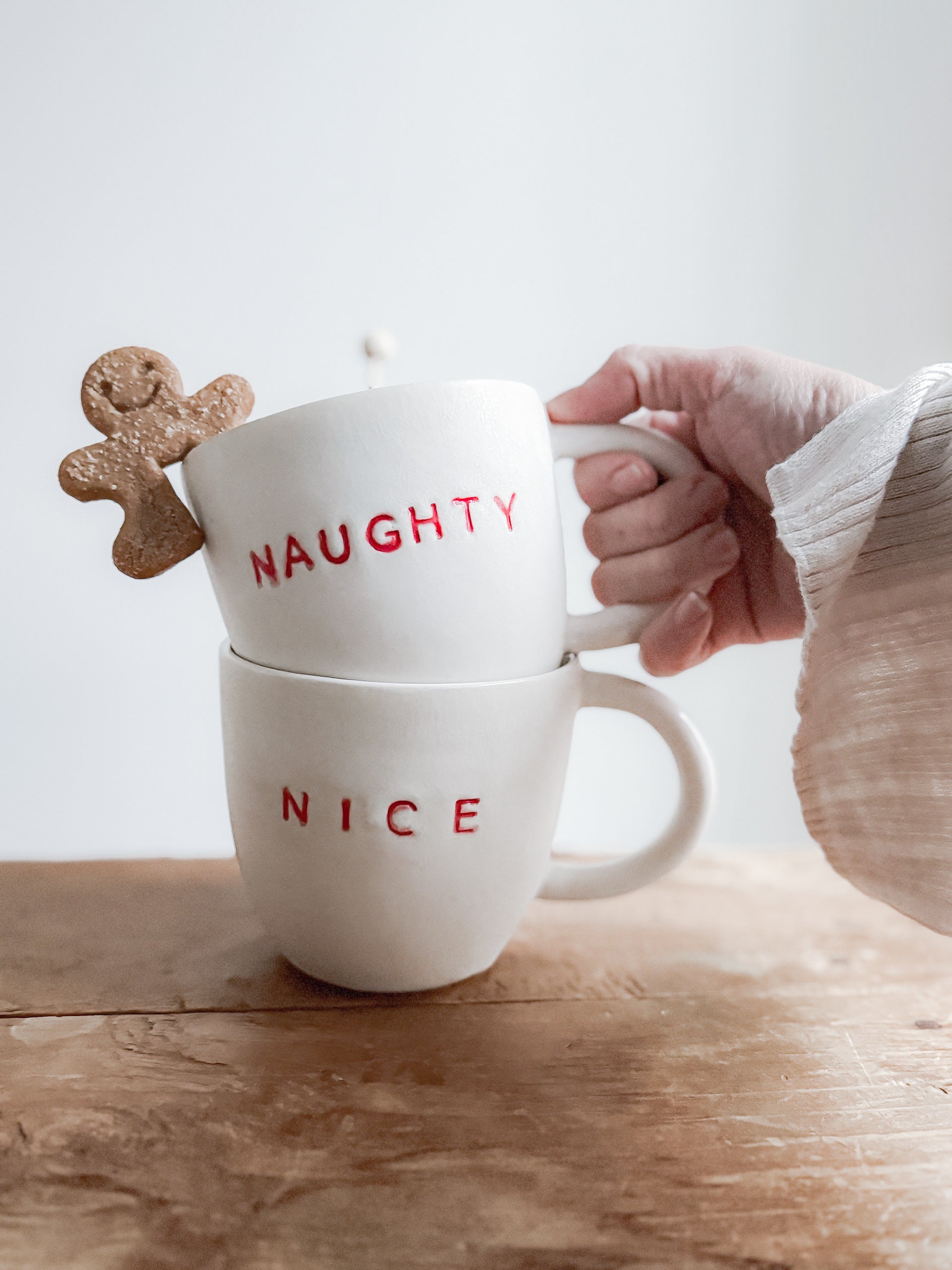 Handmade ceramic holiday mug lettered Naughty and Nice in a neutral glaze