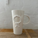 Holiday wreath ceramic mug, side view showing the wreath design on both sides