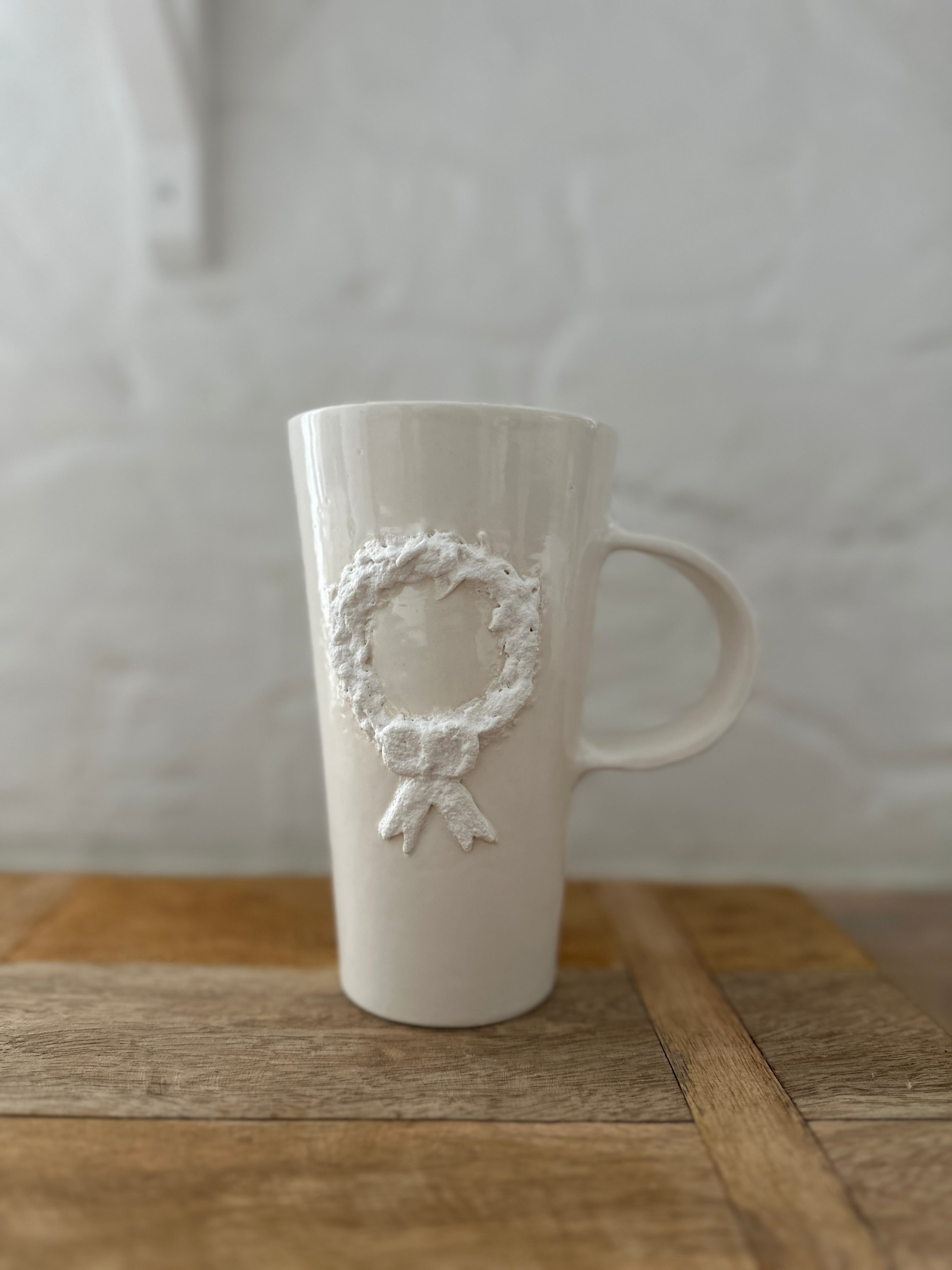 Holiday wreath ceramic mug, side view showing the wreath design on both sides
