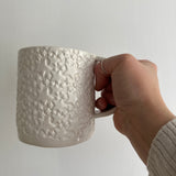 Handmade star-textured ceramic mug in white with a chunky, rounded silhouette