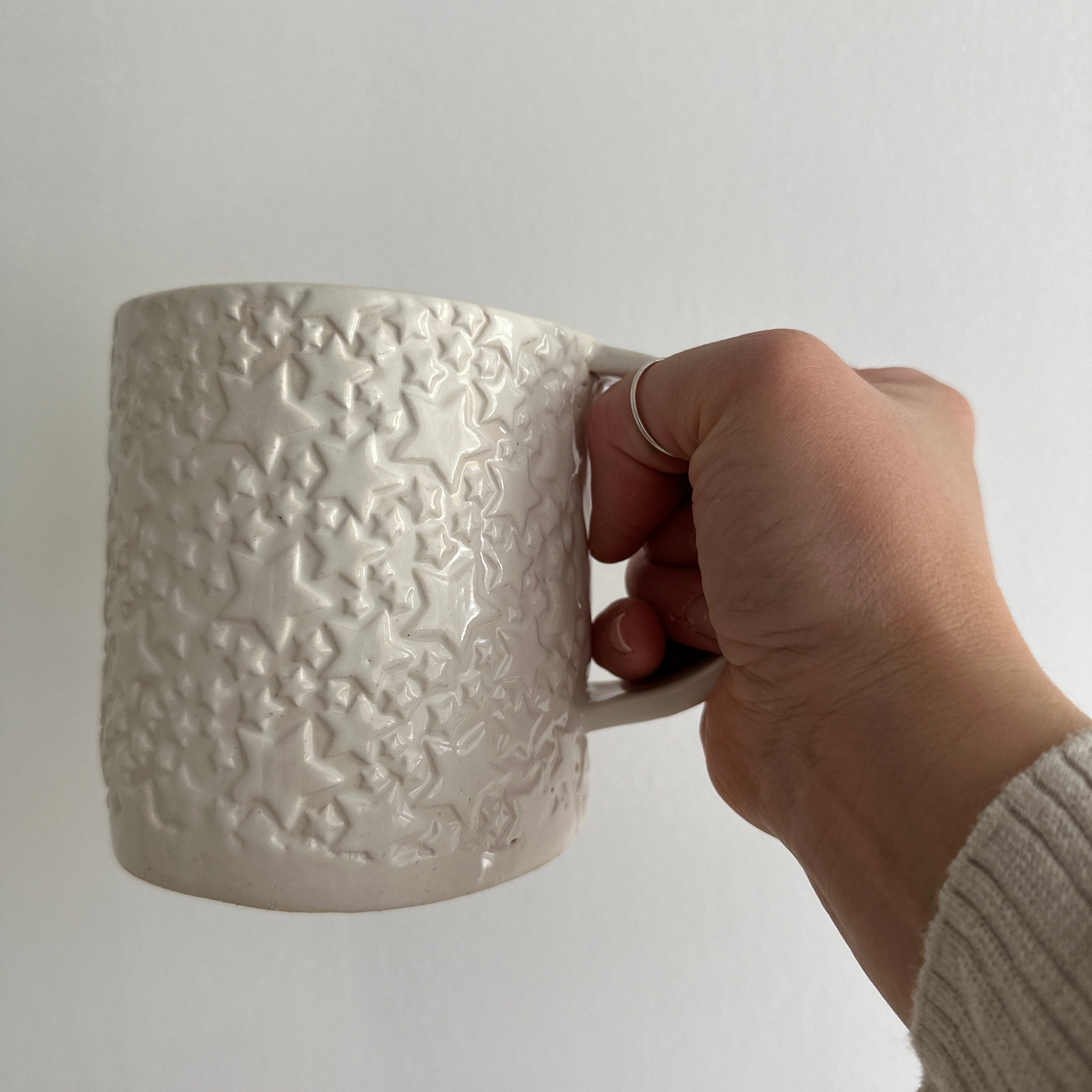 Handmade star-textured ceramic mug in white with a chunky, rounded silhouette