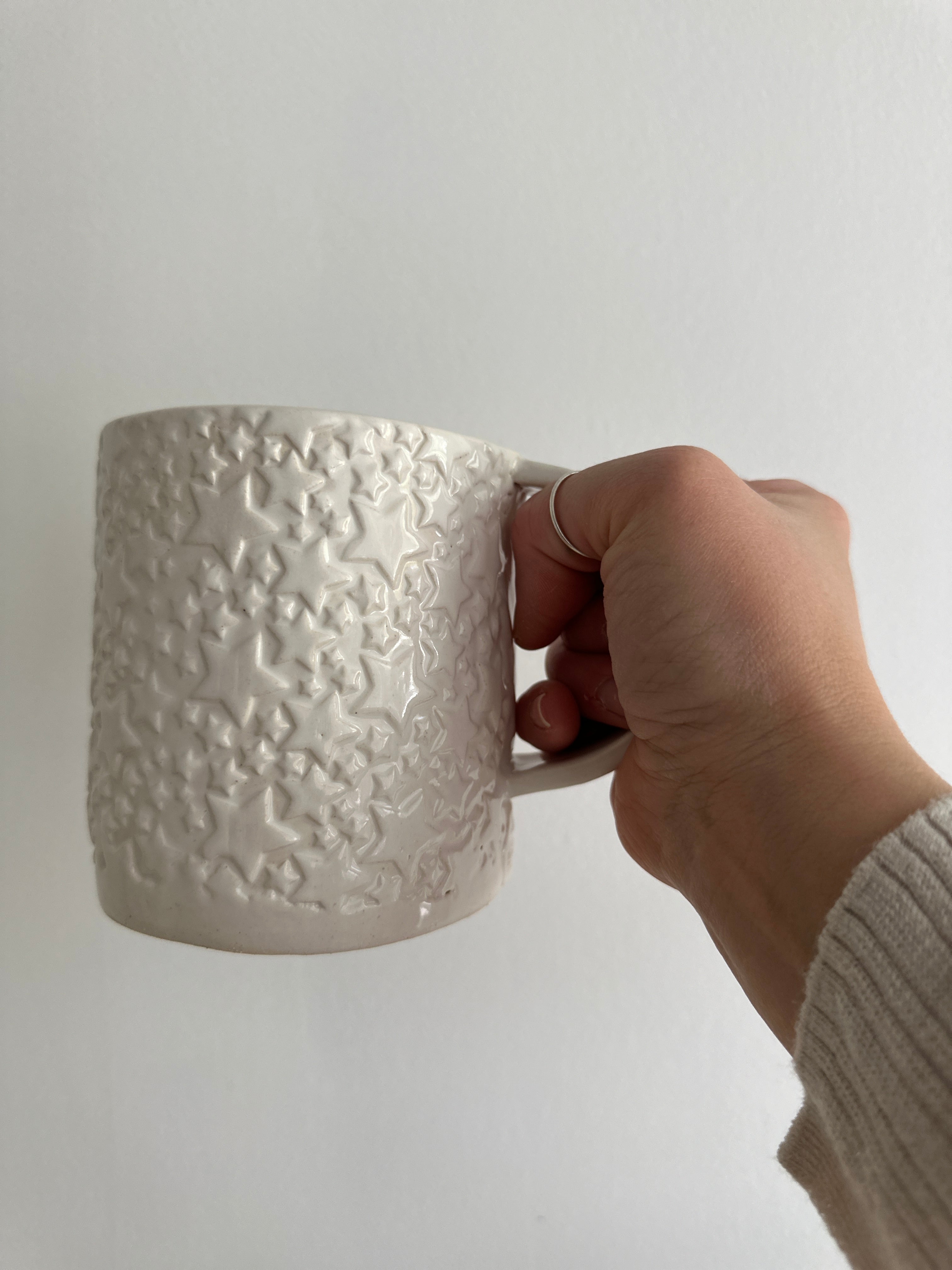 Handmade star-textured ceramic mug in white with a chunky, rounded silhouette