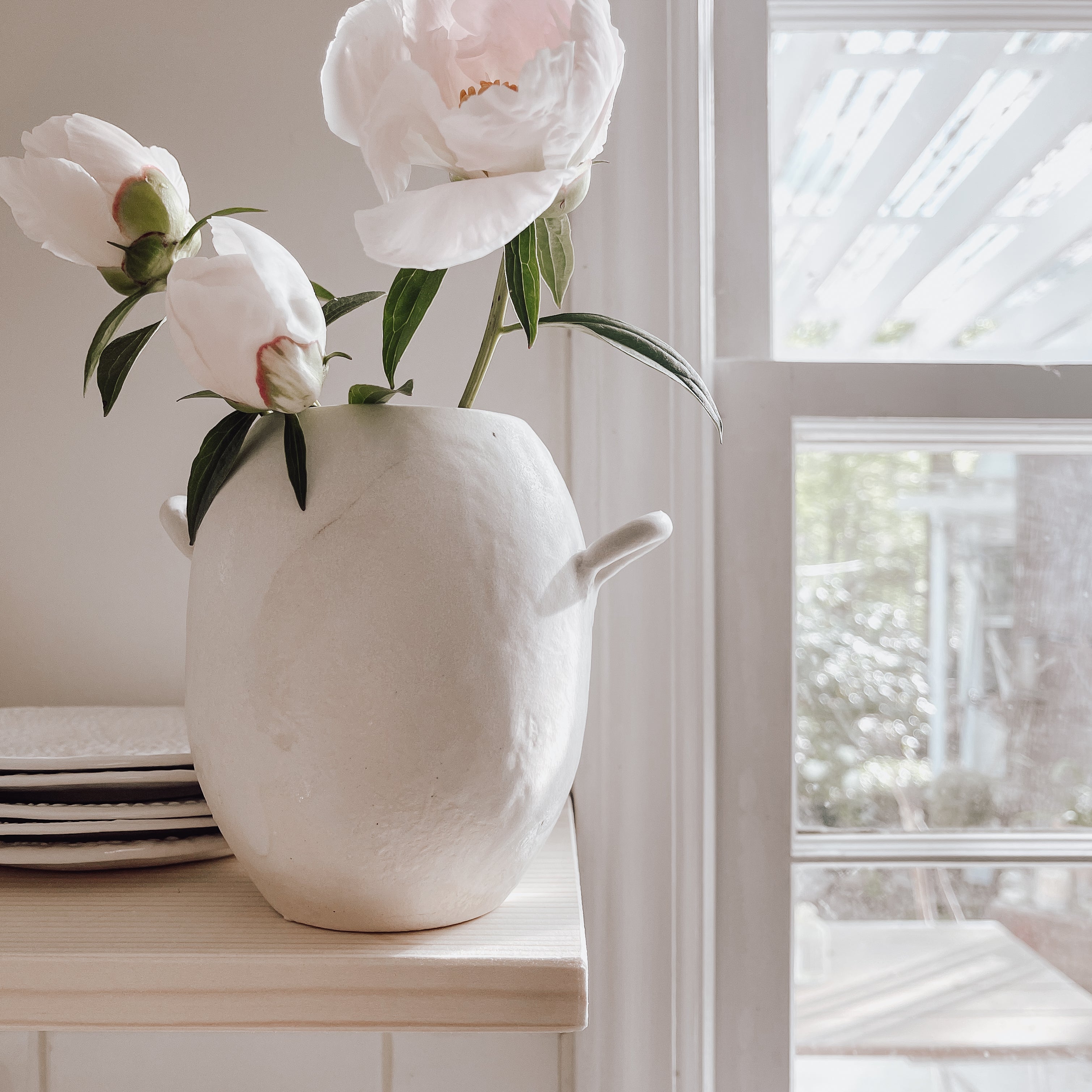 Handmade ceramic bud vase with a bellied shape and small handle