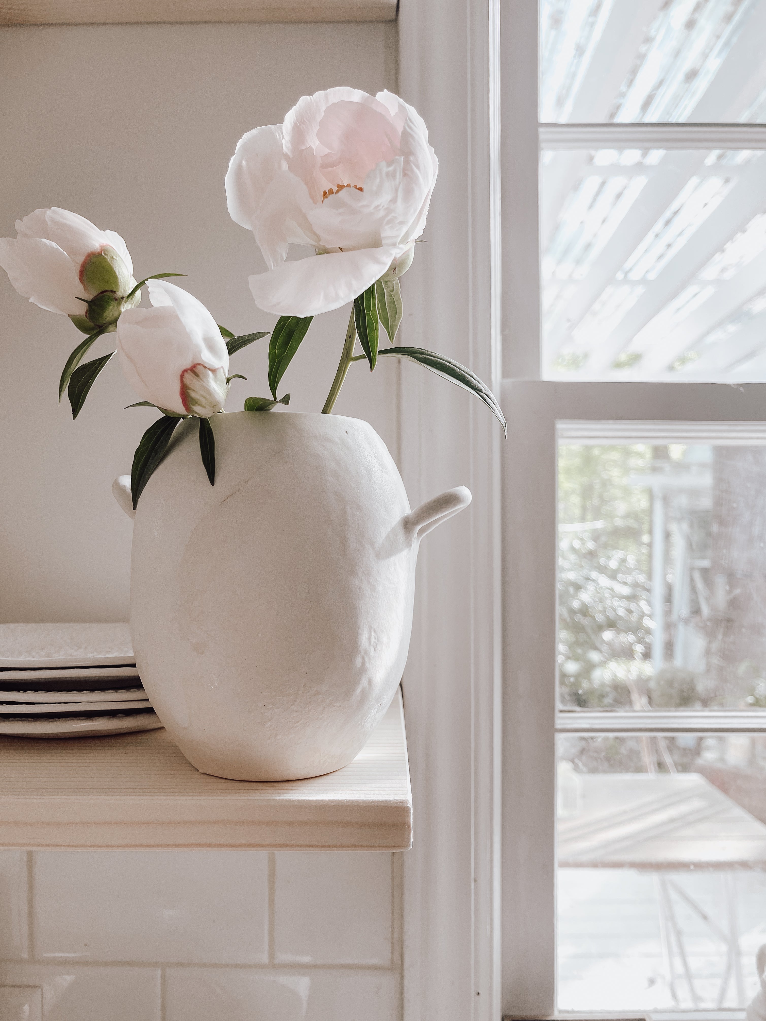 Handmade ceramic bud vase with a bellied shape and small handle