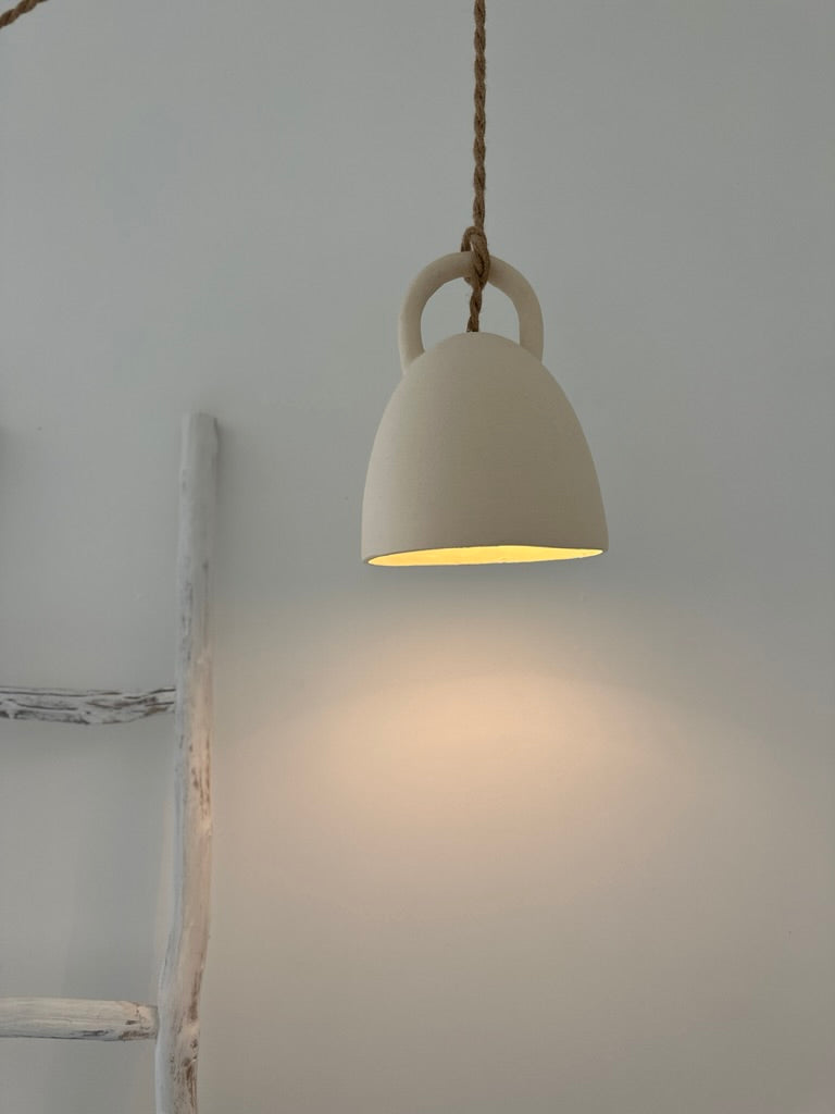 Handmade open-bell ceramic pendant light shown lit