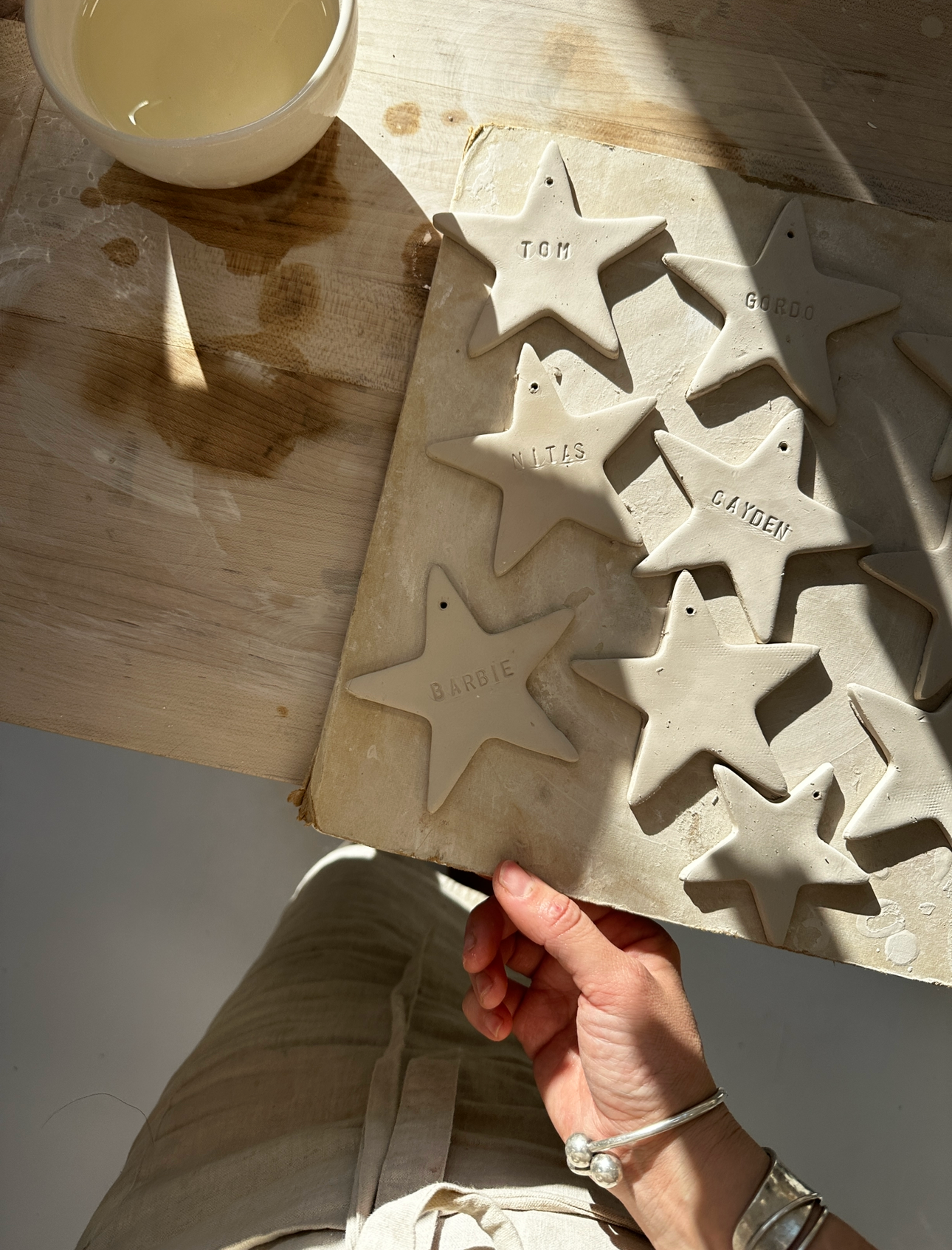Close-up of a hand-lettered name on a white porcelain star ornament
