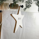 Handmade porcelain star ornament tied with linen twine, personalized as a gift tag