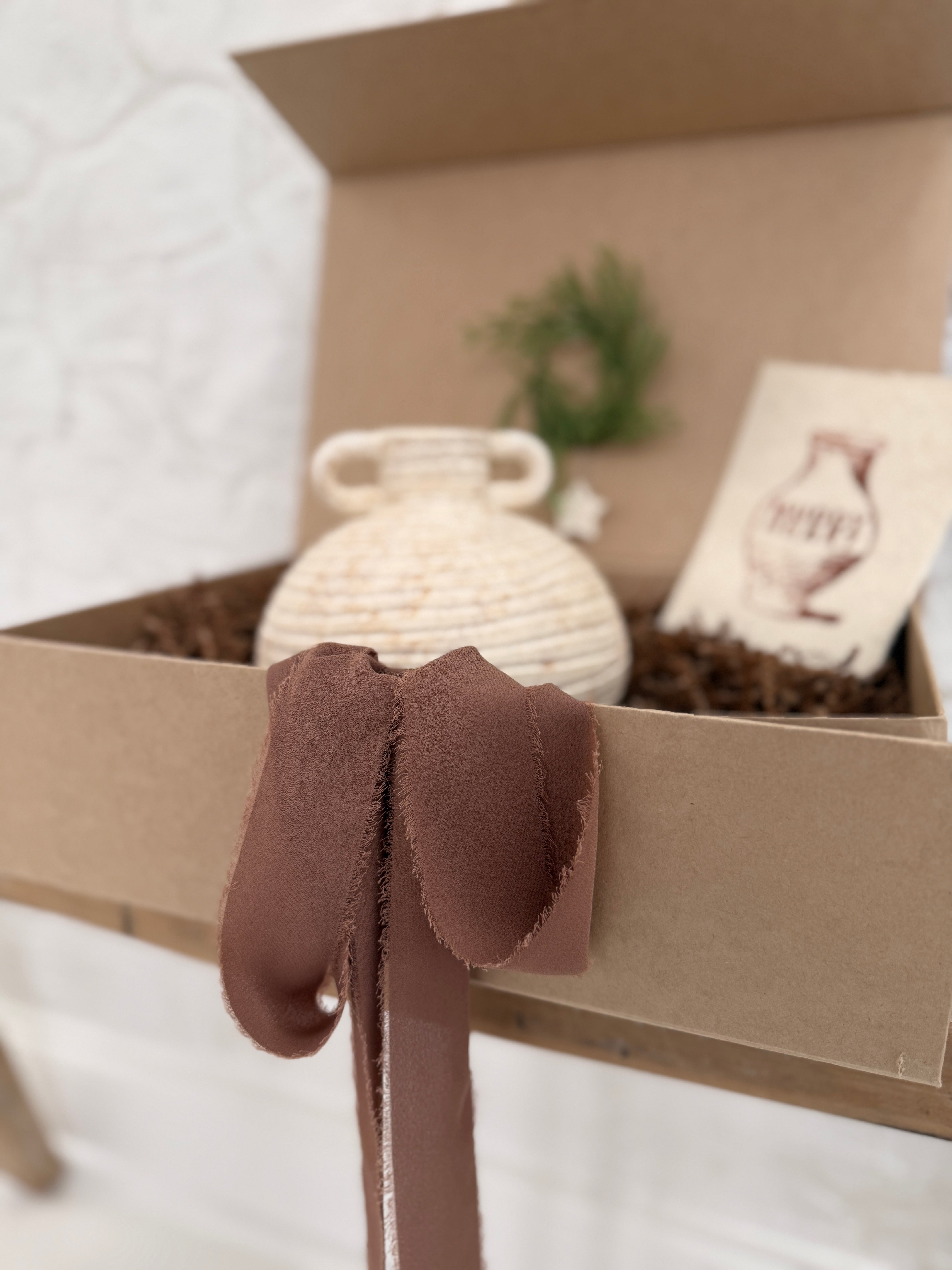 Small handmade ceramic vessel with a softly textured neutral finish, styled as a vase and shelf accent.
