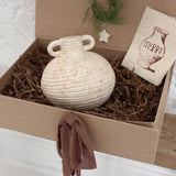 Small handmade ceramic vessel with a softly textured neutral finish, styled as a vase and shelf accent.