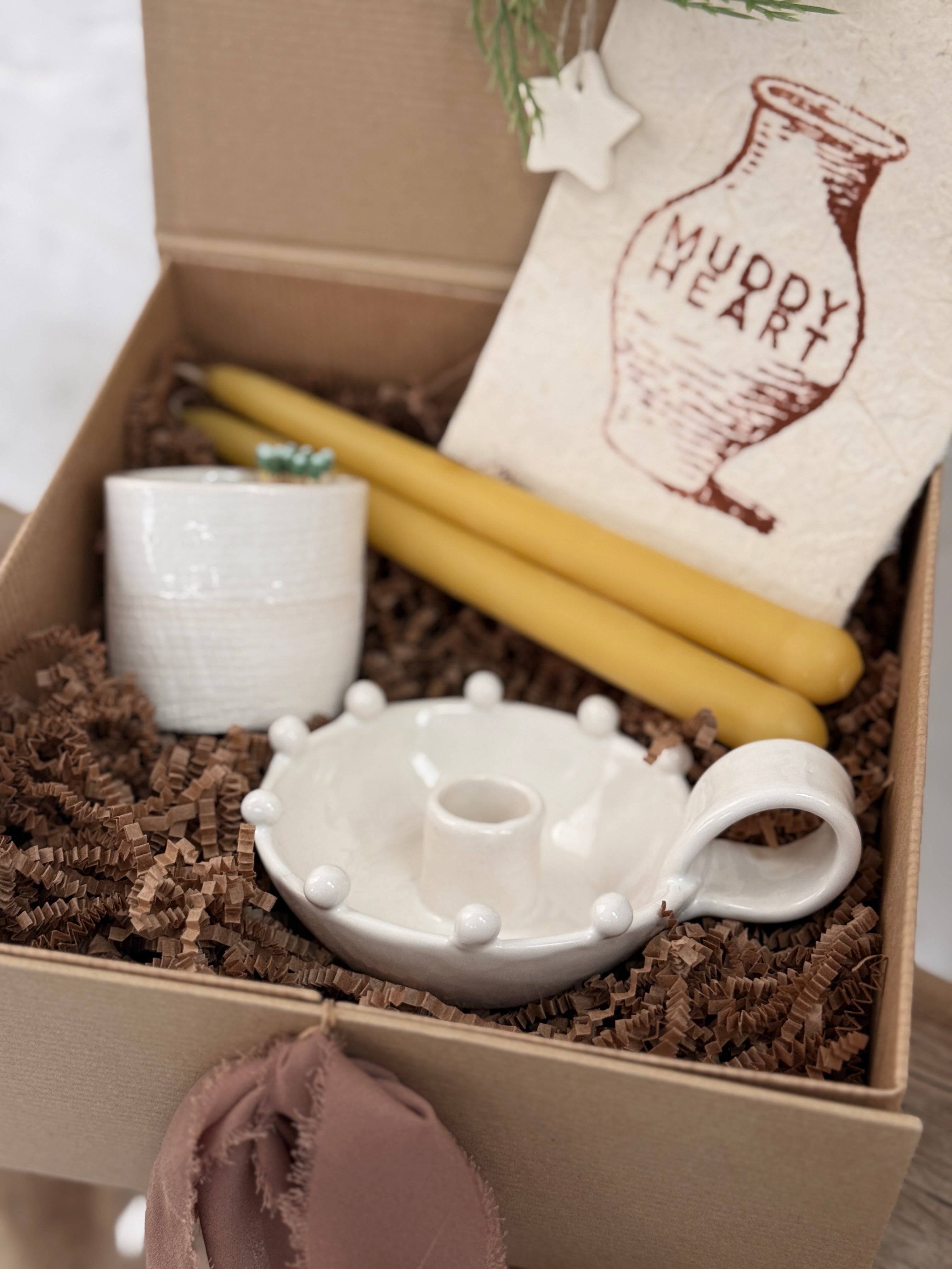 Handmade ceramic candle holder with a pair of beeswax candles and a ceramic match striker, arranged as a gift set.