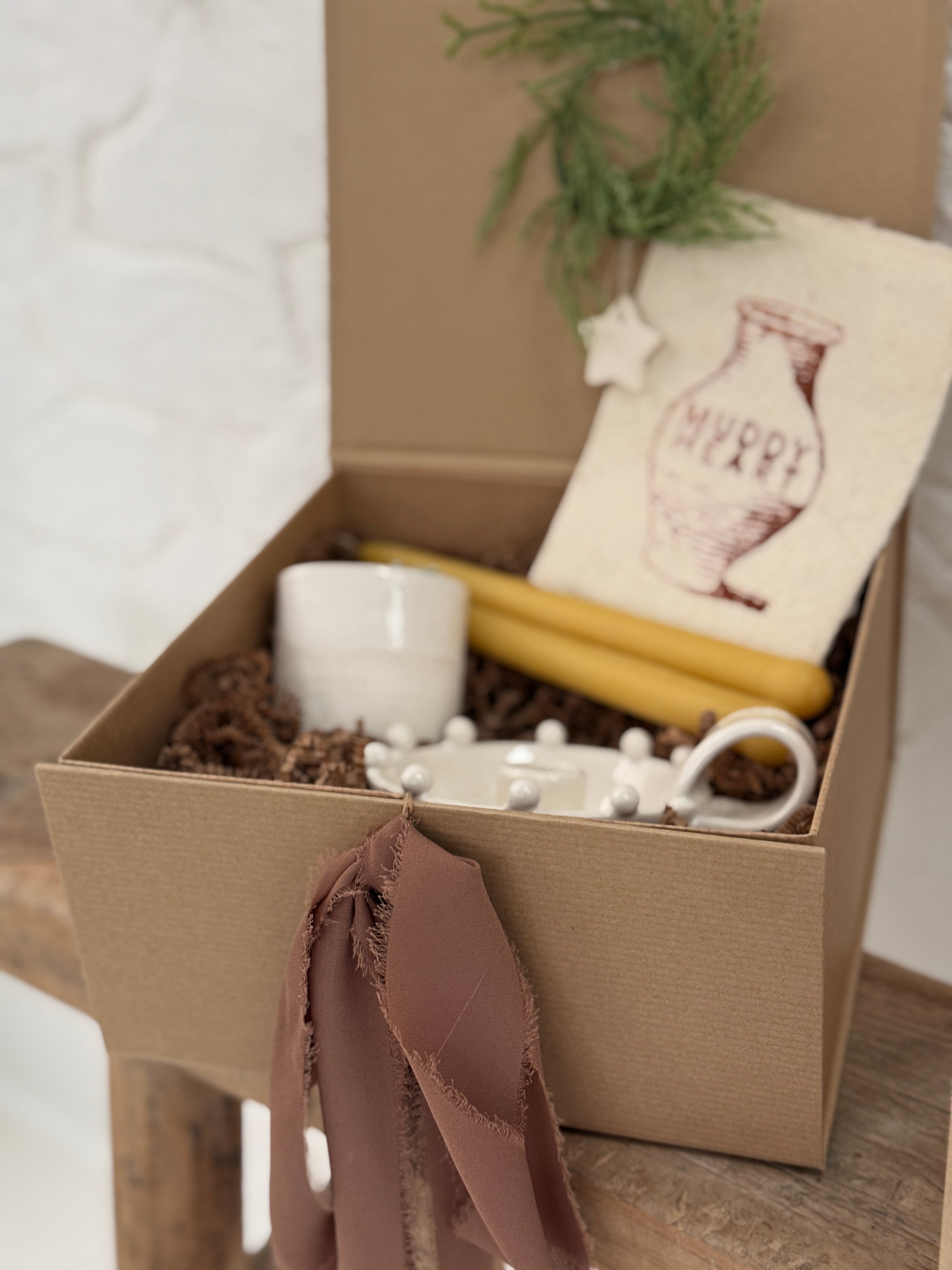 Handmade ceramic candle holder with a pair of beeswax candles and a ceramic match striker, arranged as a gift set.