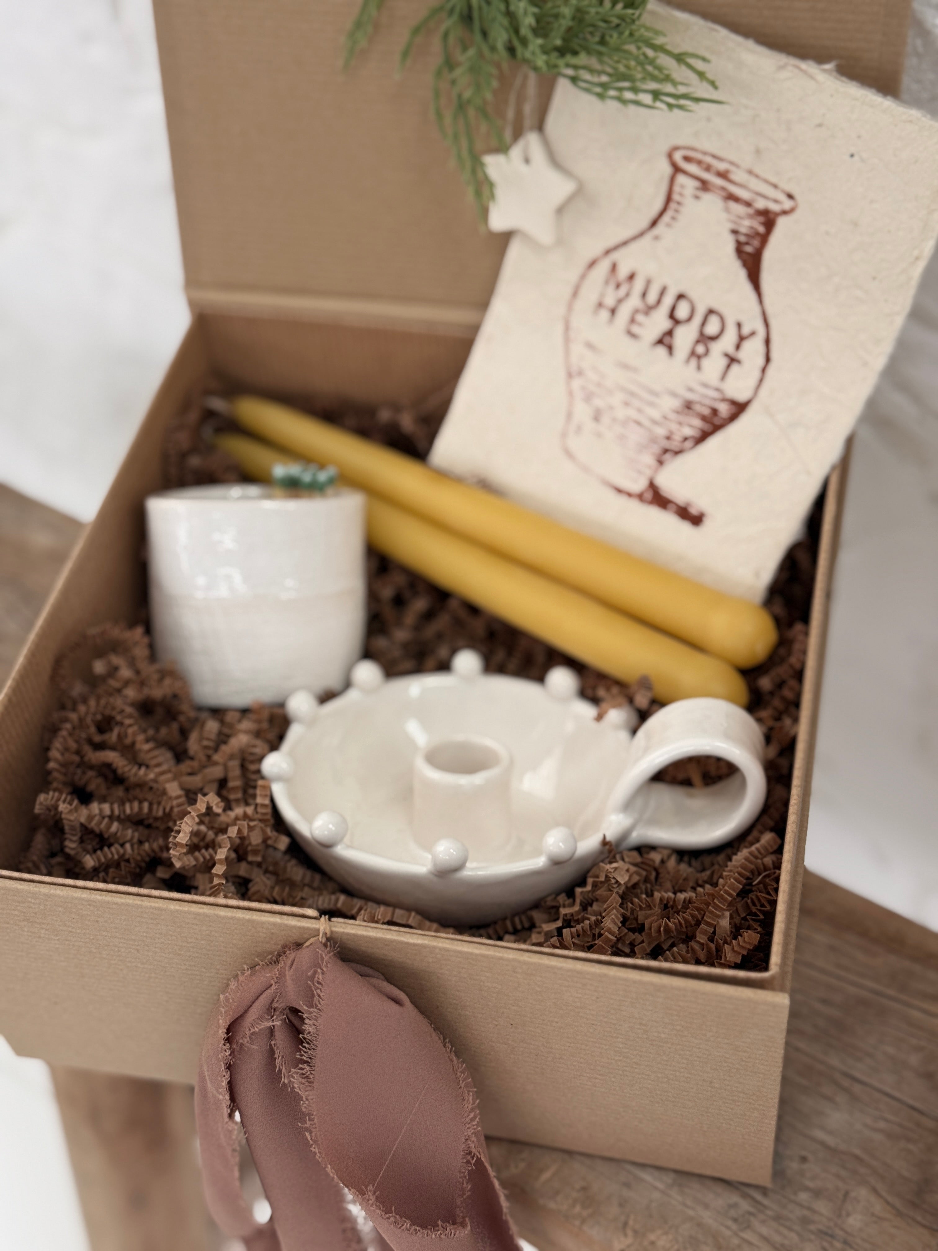 Handmade ceramic candle holder with a pair of beeswax candles and a ceramic match striker, arranged as a gift set.